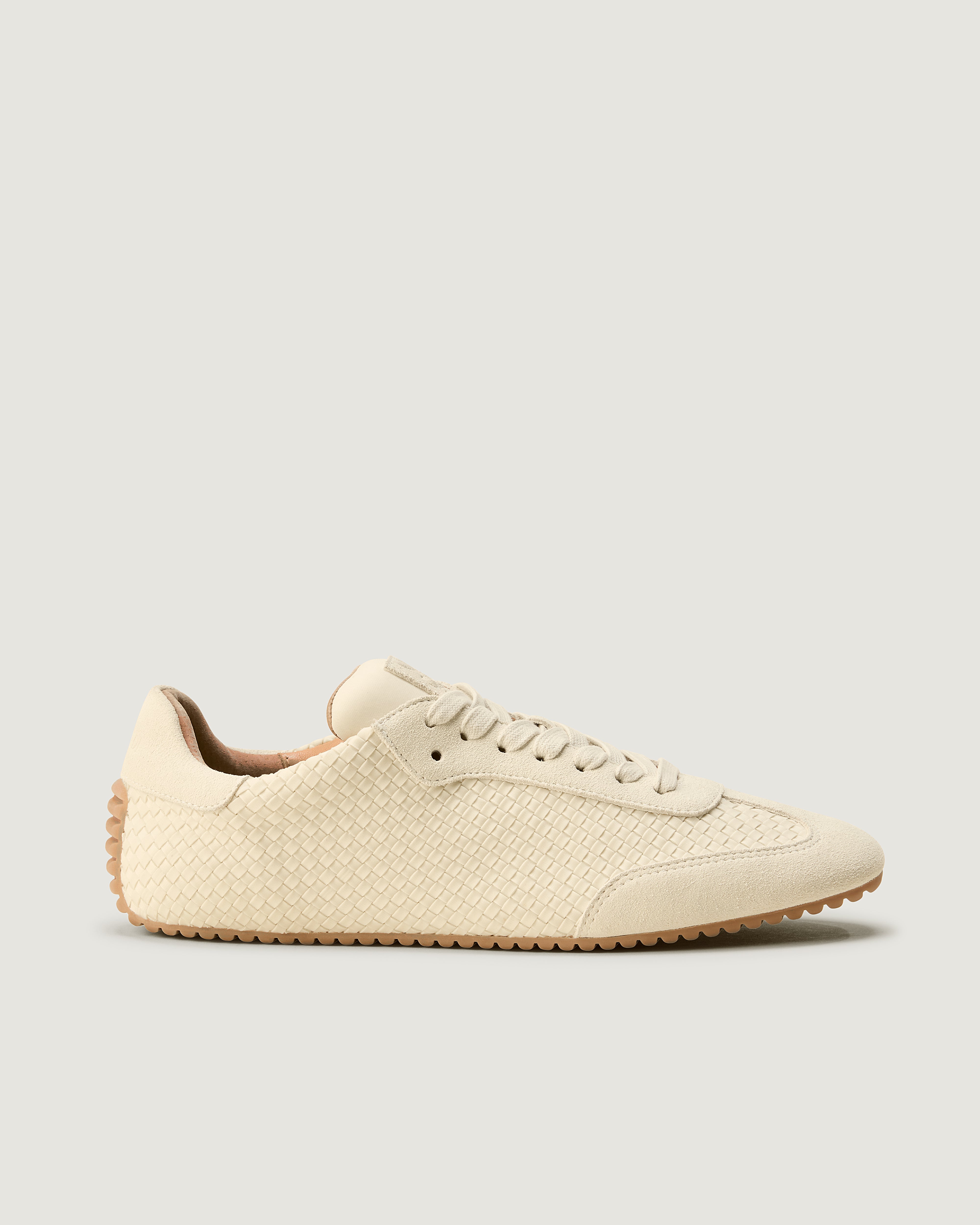 Side view of The Milan Sneaker in Salt, a bone white tone, featuring a closed toe and almond silhouette.