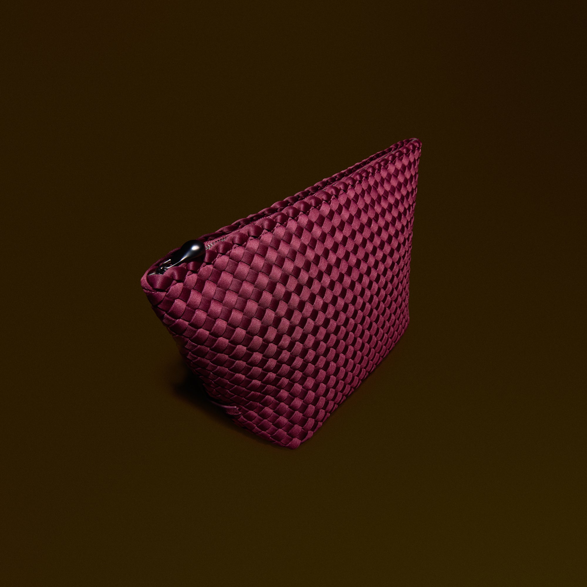 Portofino Cosmetic Pouch in Bordeaux, a rich burgundy tone, in handwoven neoprene, featuring a zip closure.