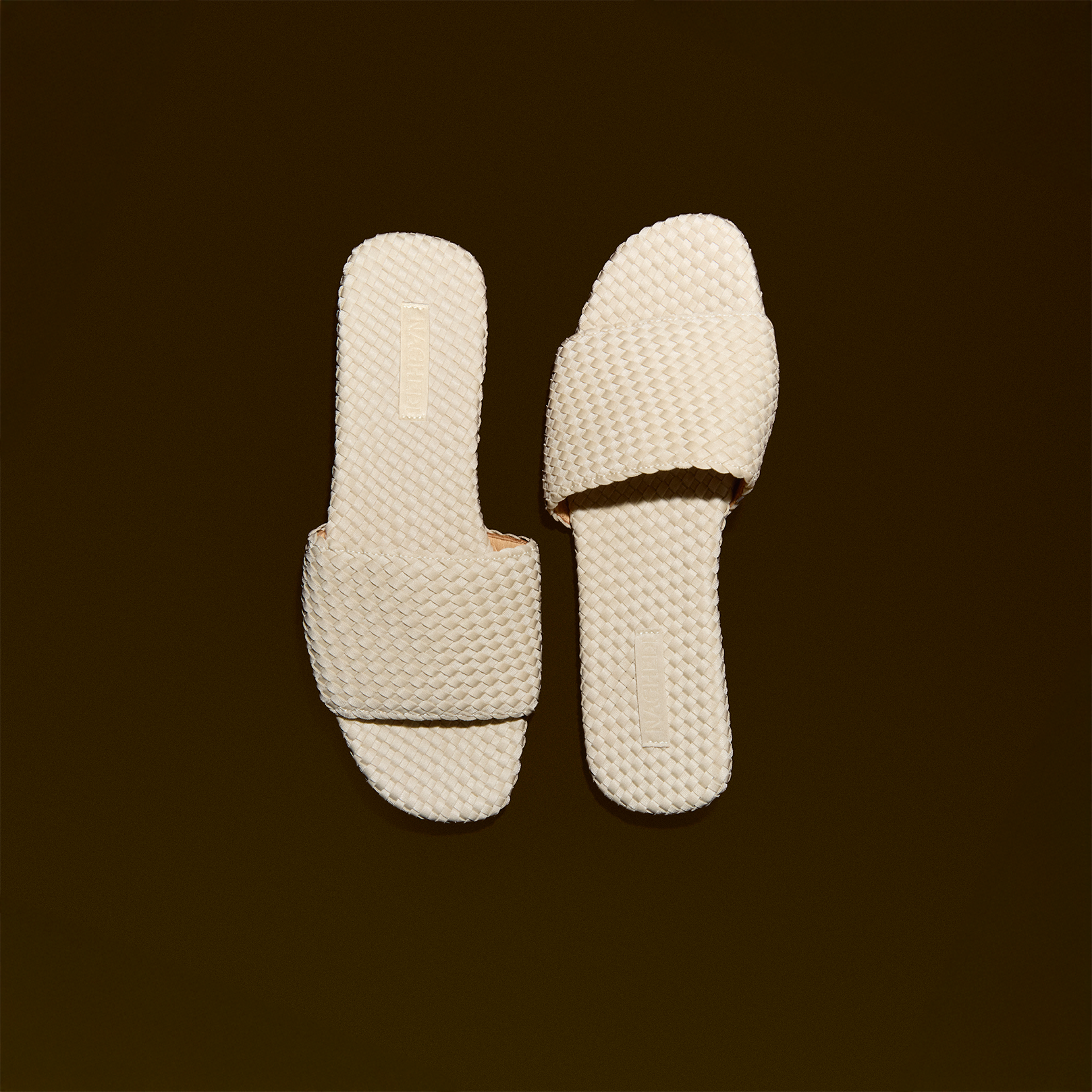 Side view of The St. Barths Slide in Ecru, a cream tone, featuring an open toe and square silhouette.