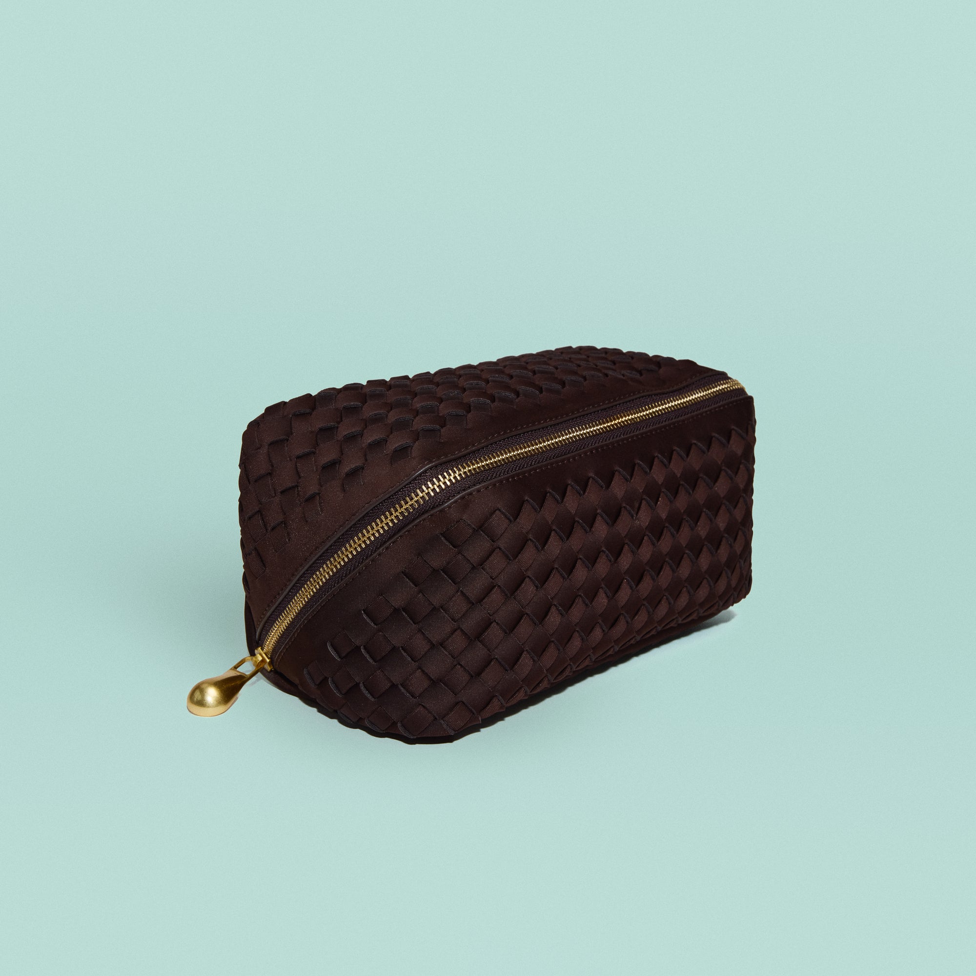 Caravan Cosmetic Case in Chocolate, a dark chocolate brown tone, in handwoven neoprene, featuring a wrap-around zip closure.
