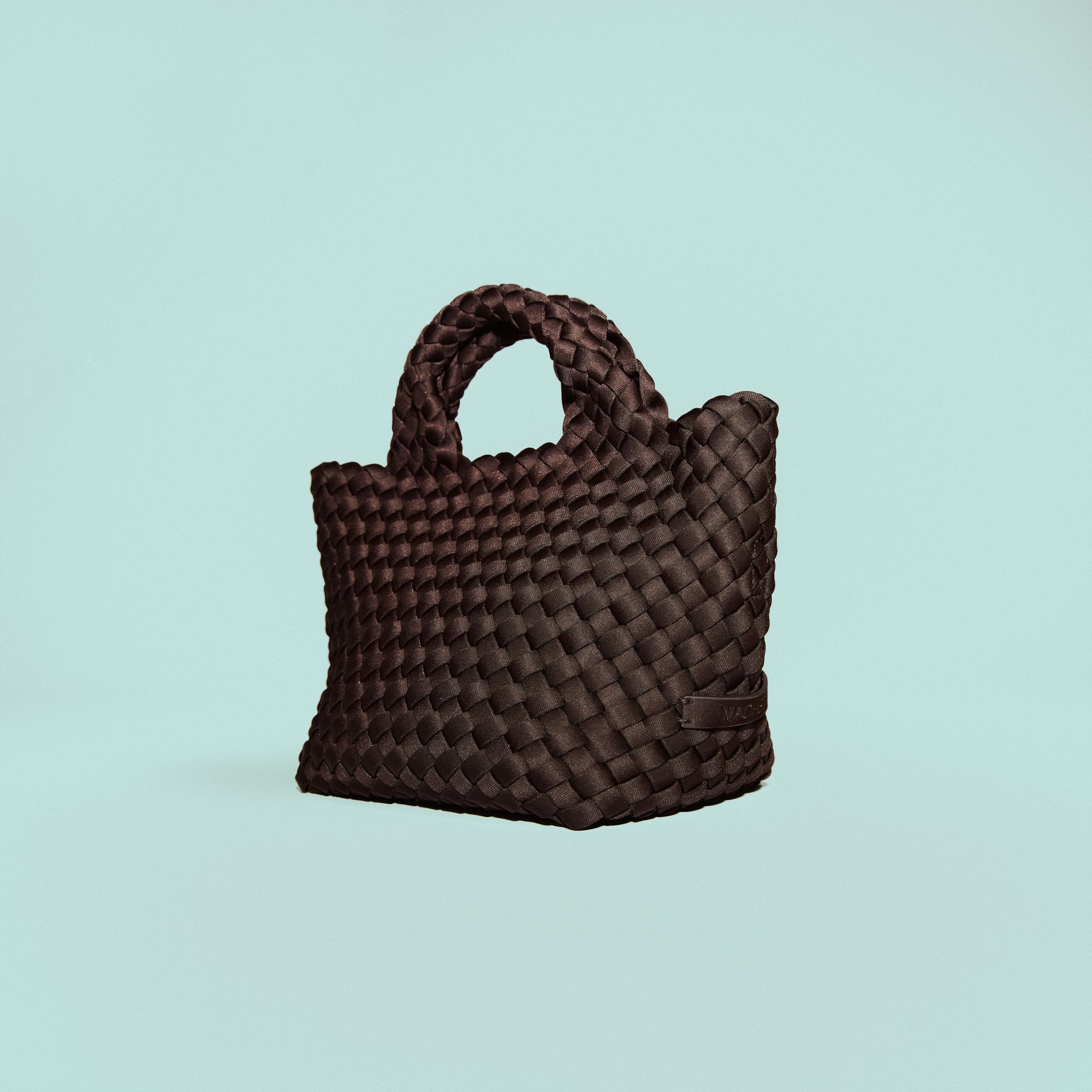 St. Barths Tote in Chocolate, a dark chocolate brown tone, in handwoven neoprene, featuring an open top, woven top handles, and detachable, adjustable nylon crossbody strap.