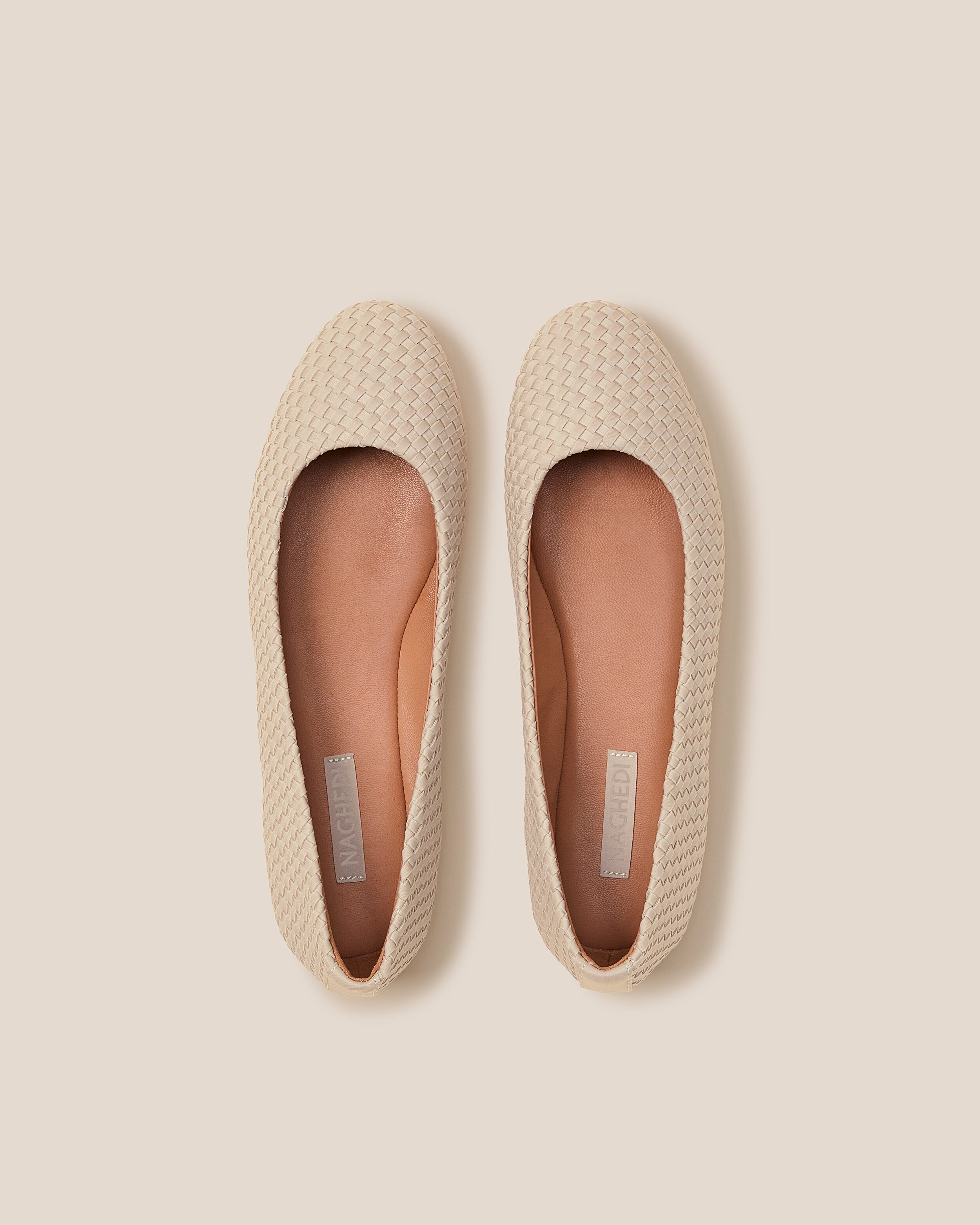 Top view of pair of The Nomad Ballet Flat in Ecru showing the natural tanned leather insole.
