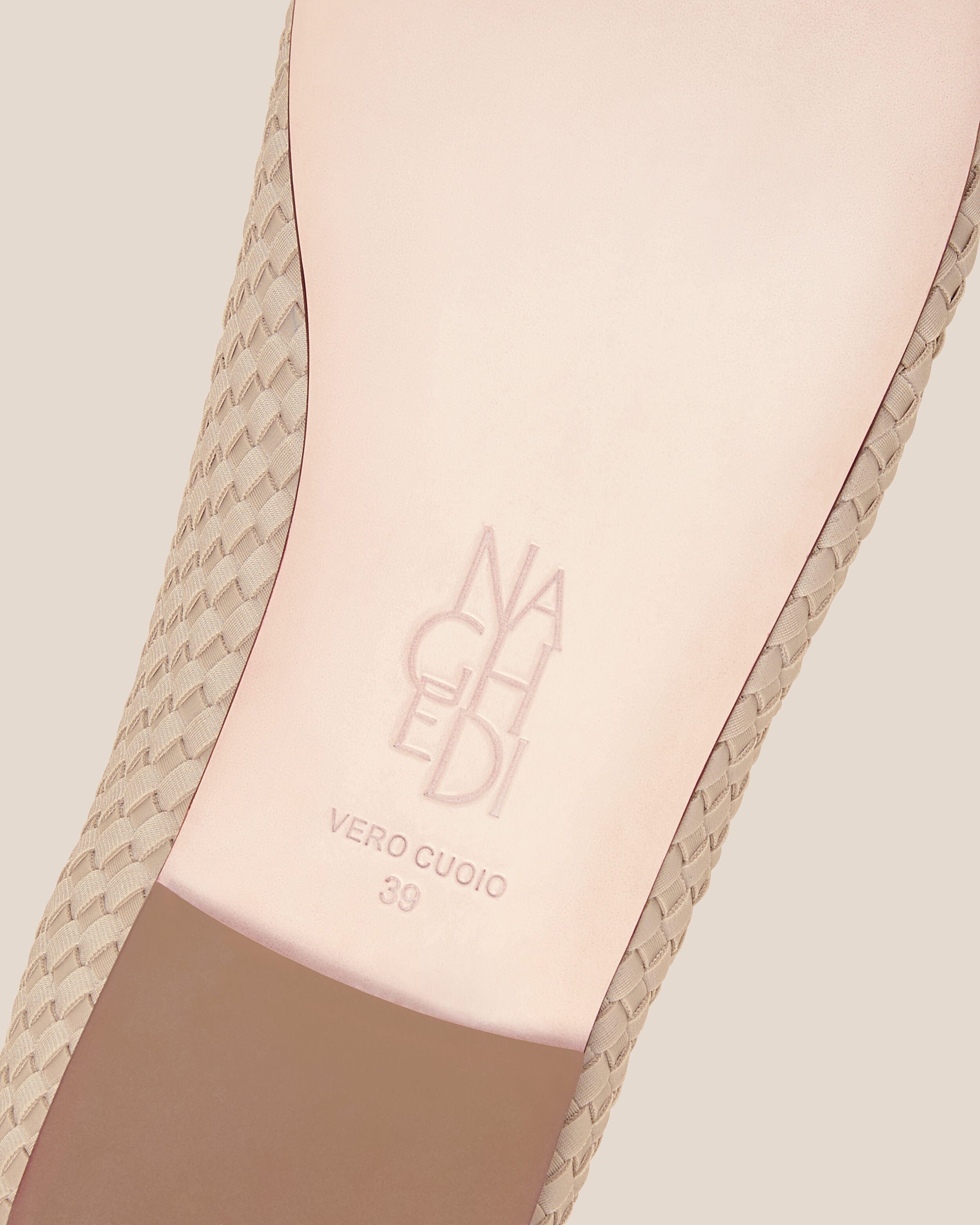 Shoe sole showing natural buffed leather sole, stamped NAGHEDI logo and size detail for The Nomad Ballet Flat in Ecru.