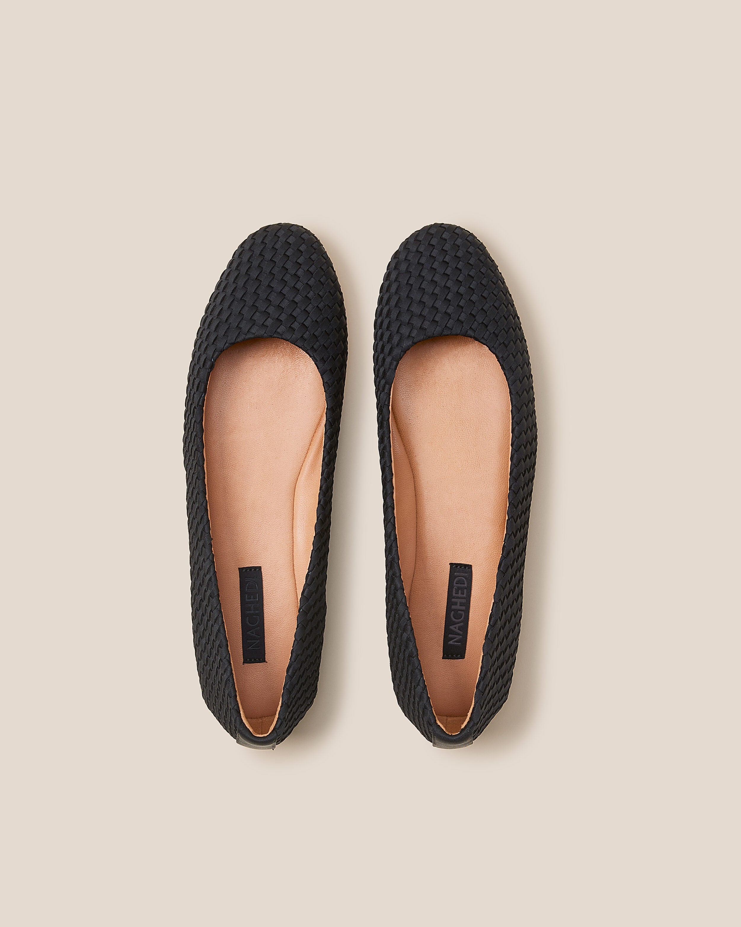 Top view of pair of The Nomad Ballet Flat in Onyx showing the natural tanned leather insole.