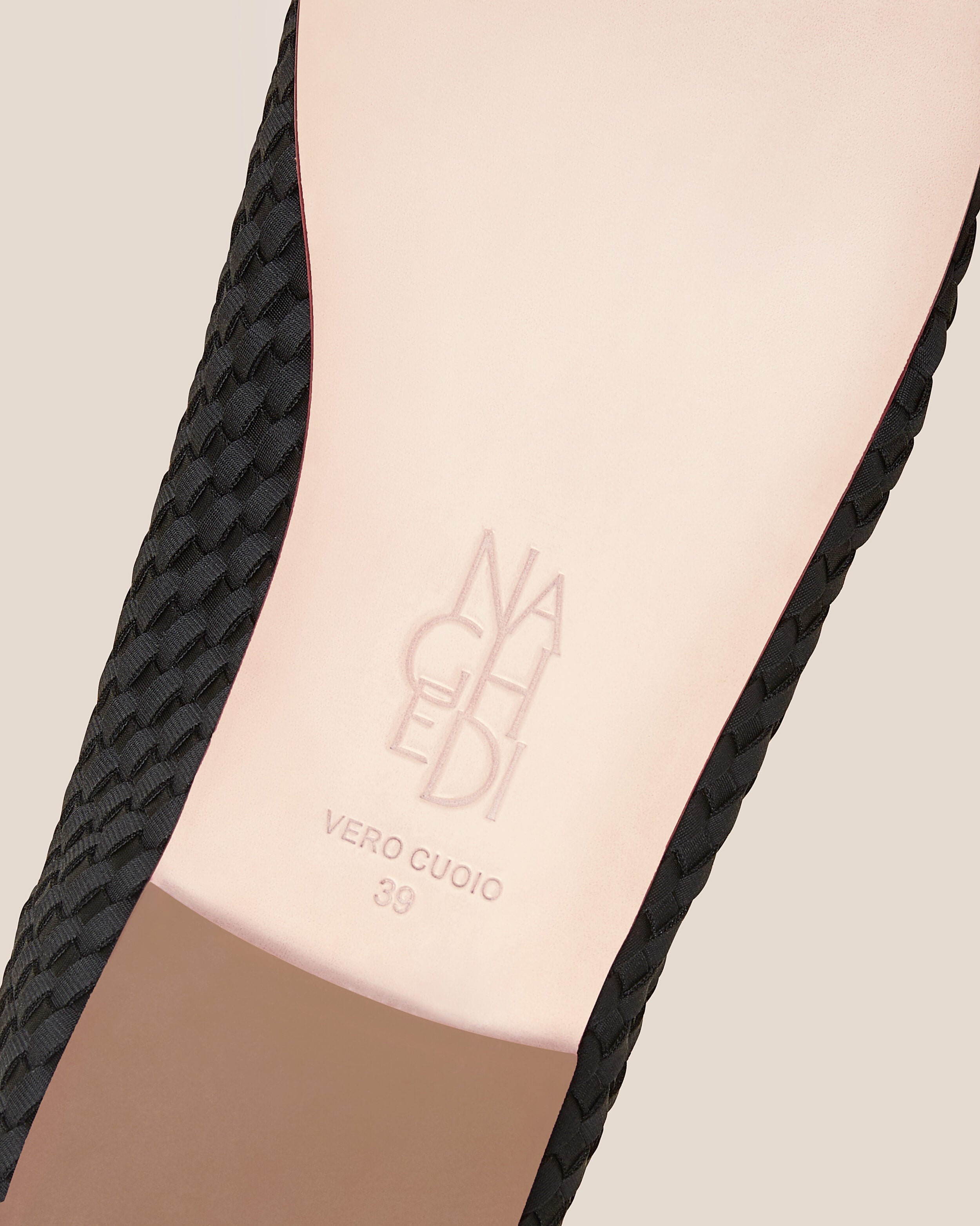 Shoe sole showing natural buffed leather sole, stamped NAGHEDI logo and size detail for The Nomad Ballet Flat in Onyx.