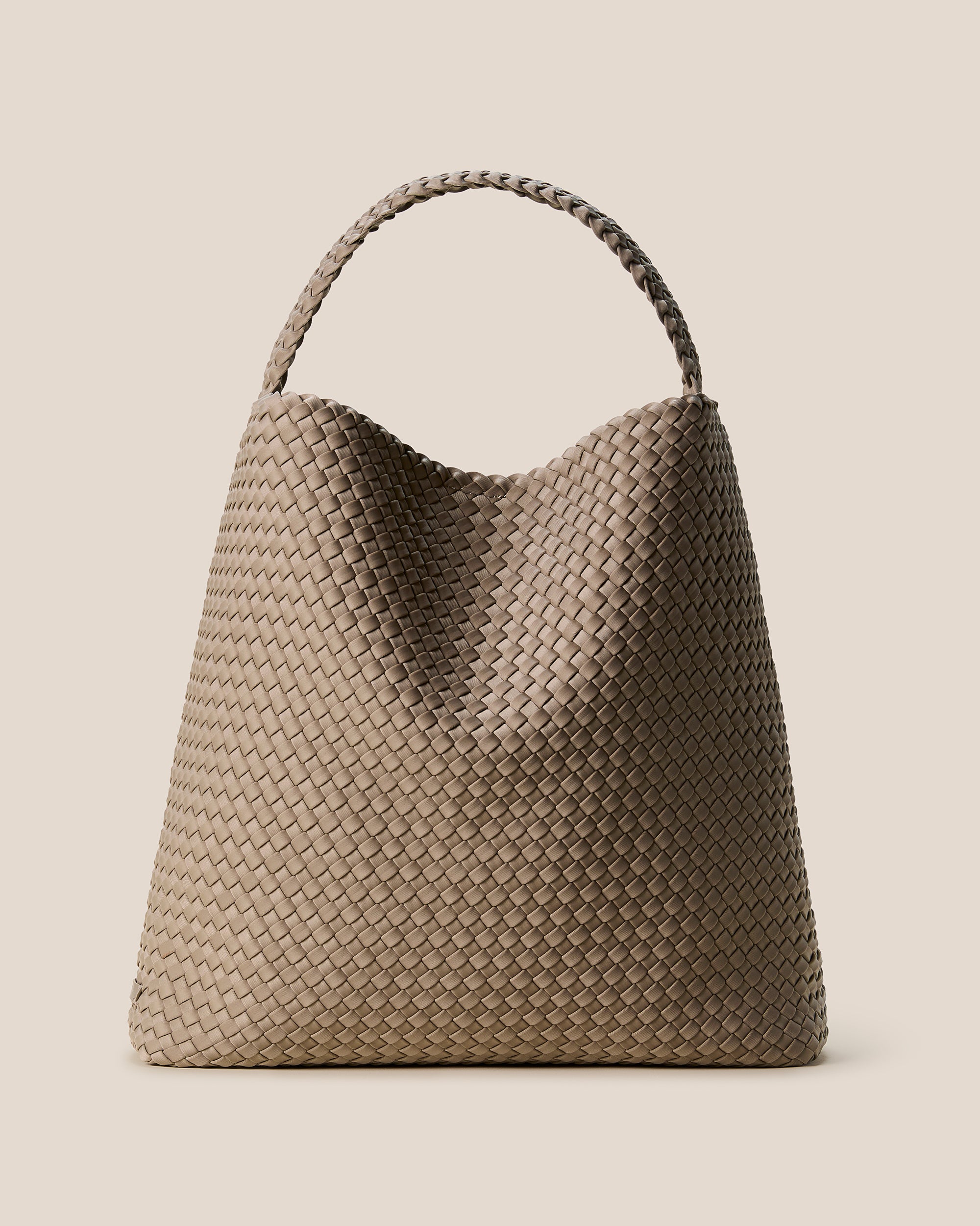Nomad Large Hobo Bag in Cashmere, a taupe tone, in handwoven neoprene featuring an open top with magnetic snap closure, and handwoven shoulder strap lays comfortably flat.