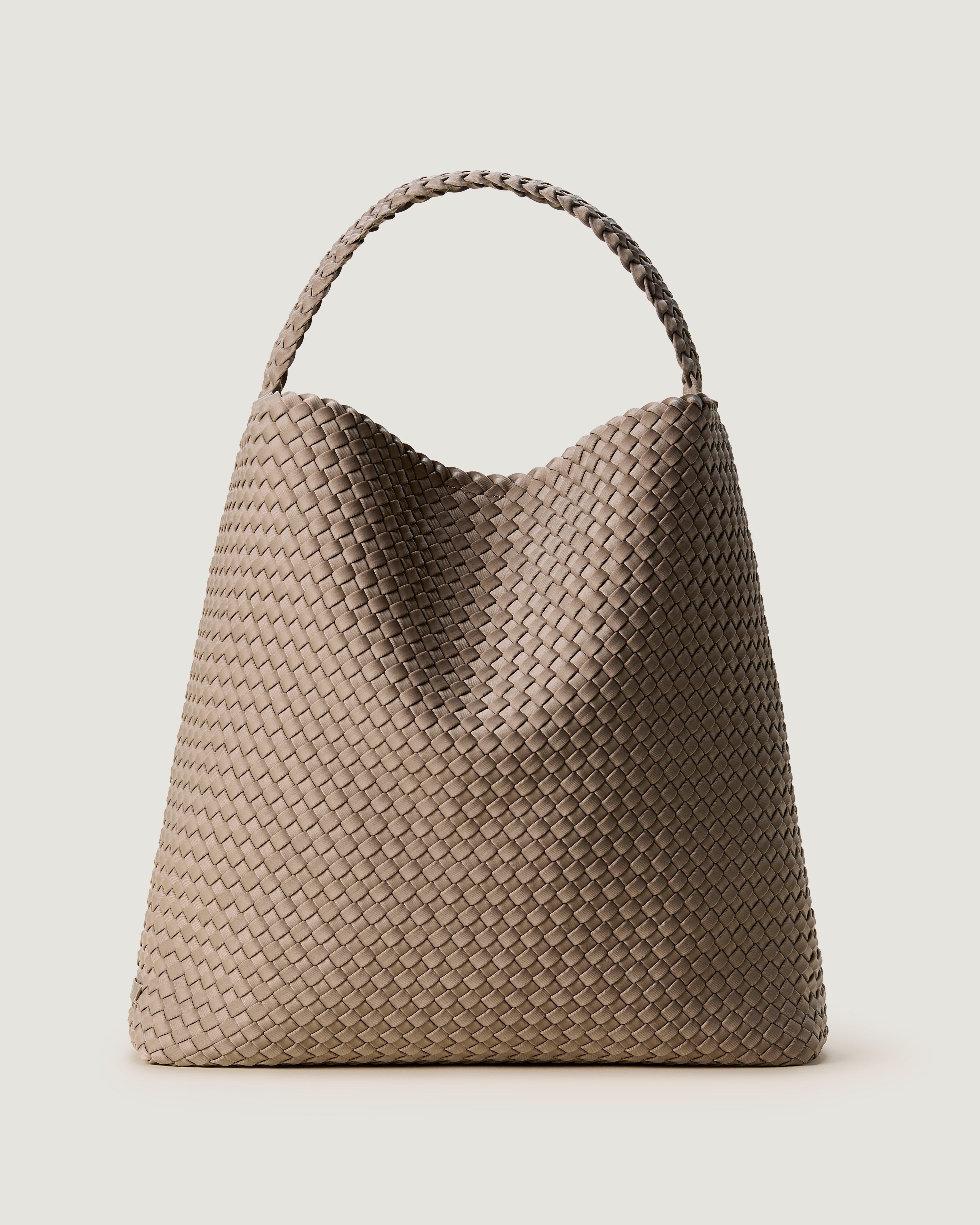 Nomad Hobo in Cashmere, a taupe tone, in handwoven neoprene, featuring an open top with magnetic snap closure, and handwoven shoulder strap lays comfortably flat.