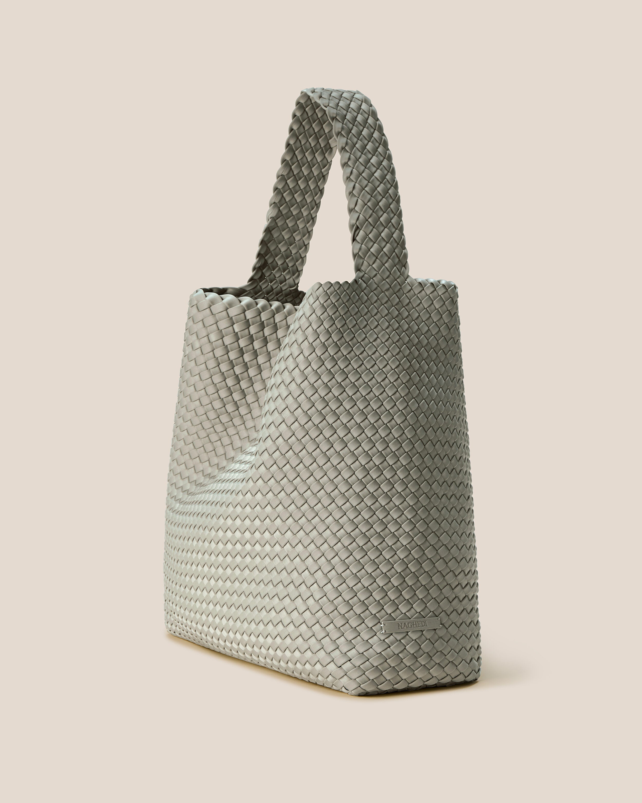 Nomad Hobo in Celadon shown from a side angle, highlighting its handwoven neoprene construction and open top with magnetic snap closure.