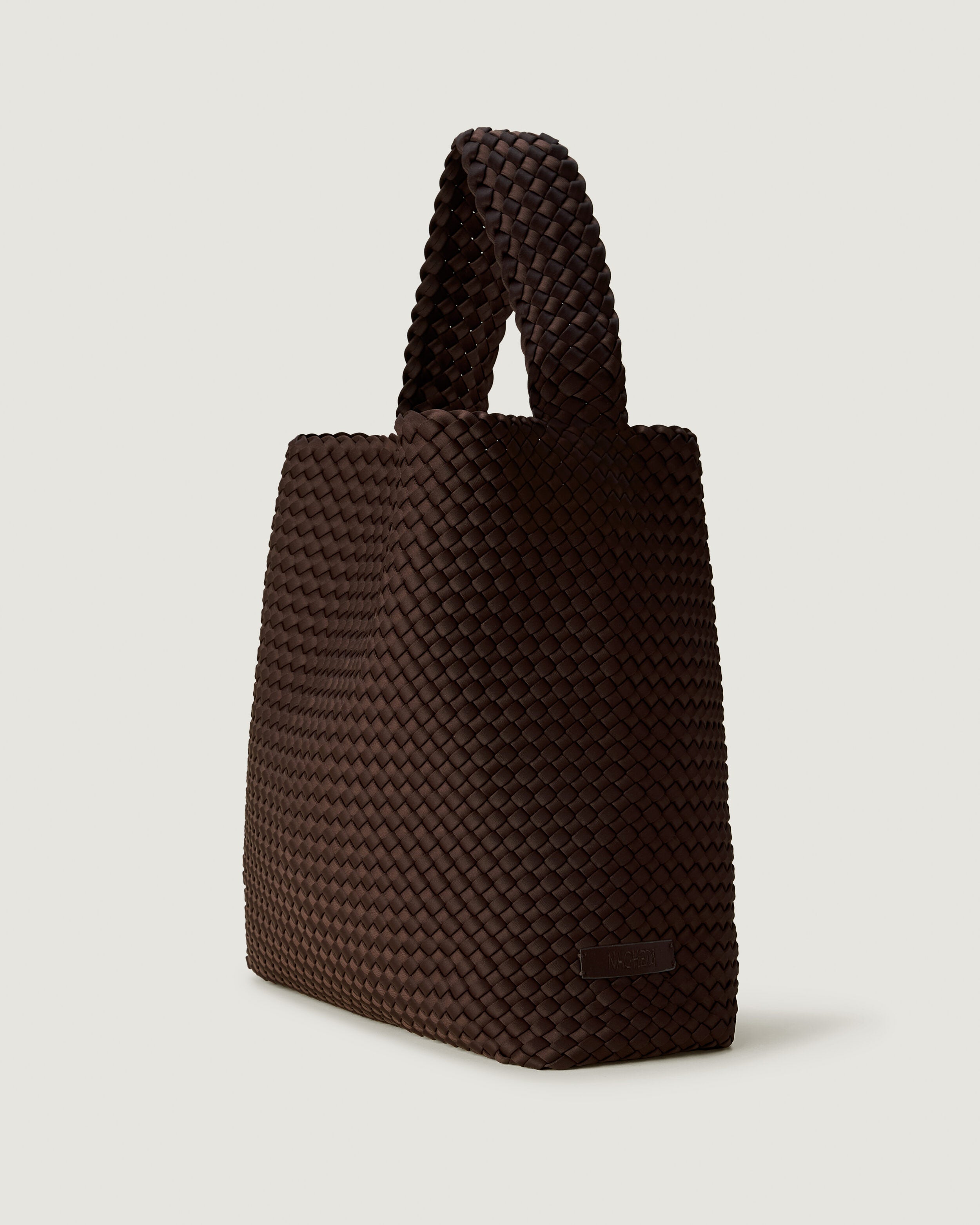 Nomad Hobo in Chocolate shown from a side angle, highlighting its handwoven neoprene construction and open top with magnetic snap closure.