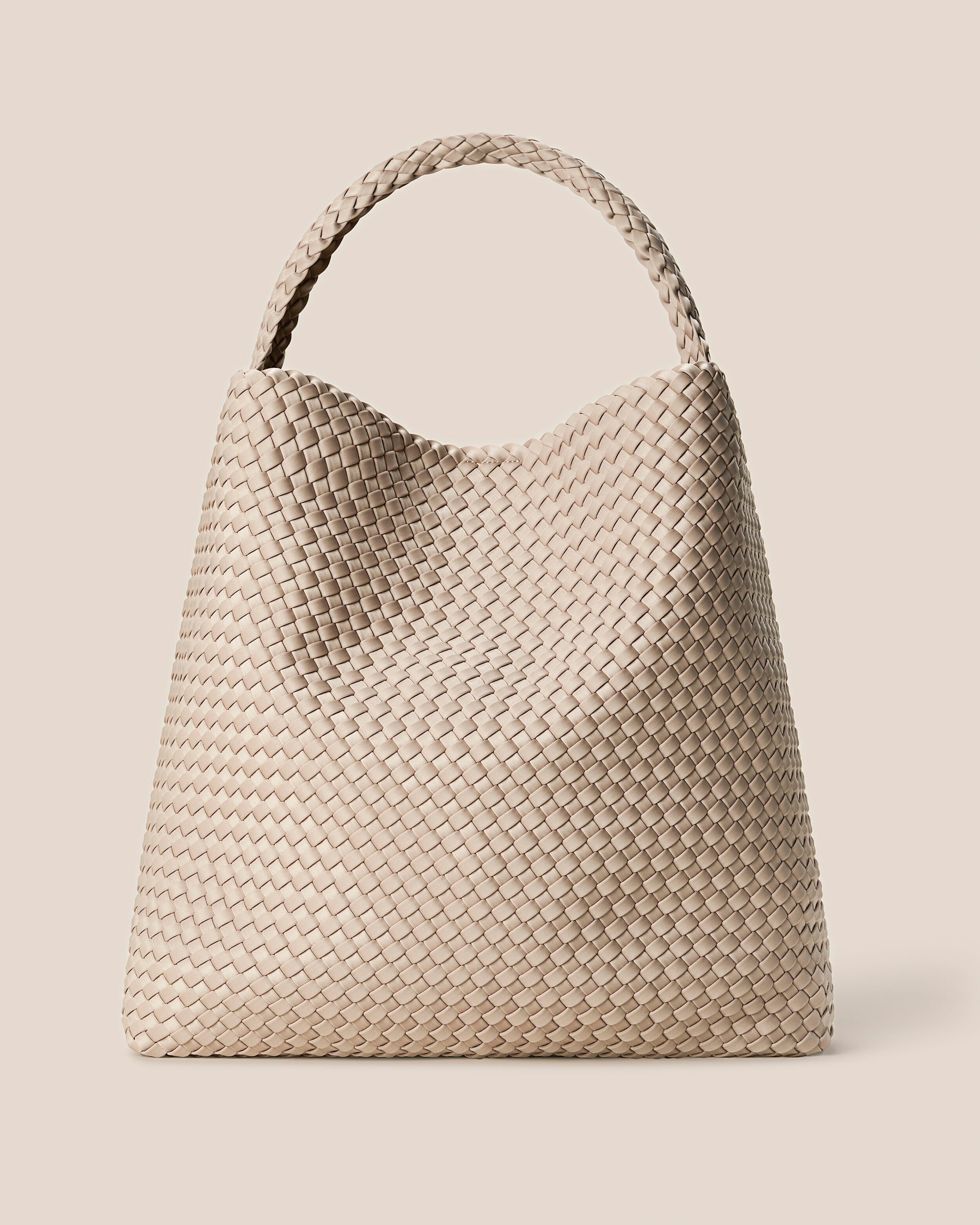 Nomad Hobo in Ecru, a cream tone, in handwoven neoprene, featuring an open top with magnetic snap closure, and handwoven shoulder strap lays comfortably flat.