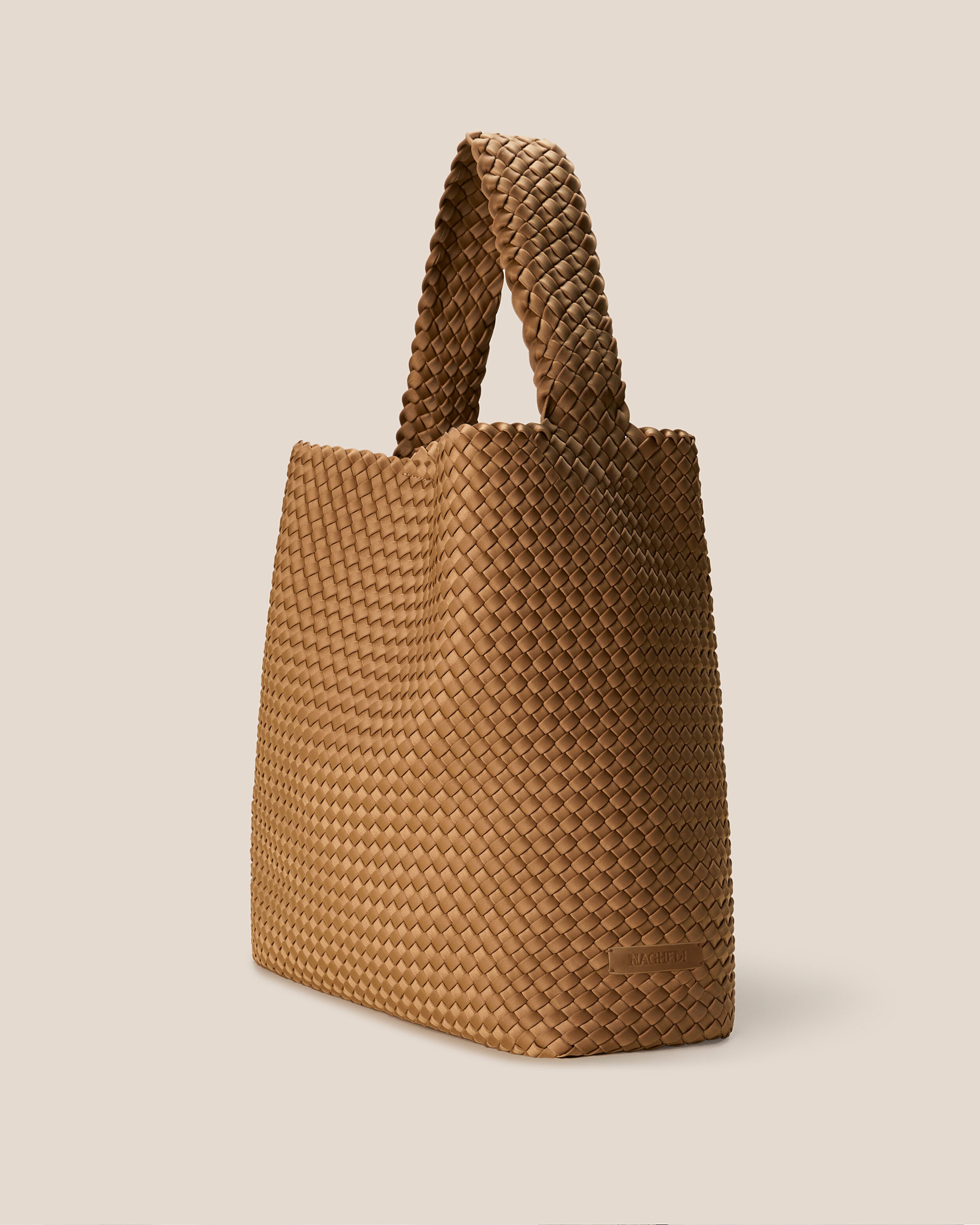 Nomad Hobo in Montauk shown from a side angle, highlighting its handwoven neoprene construction and open top with magnetic snap closure.