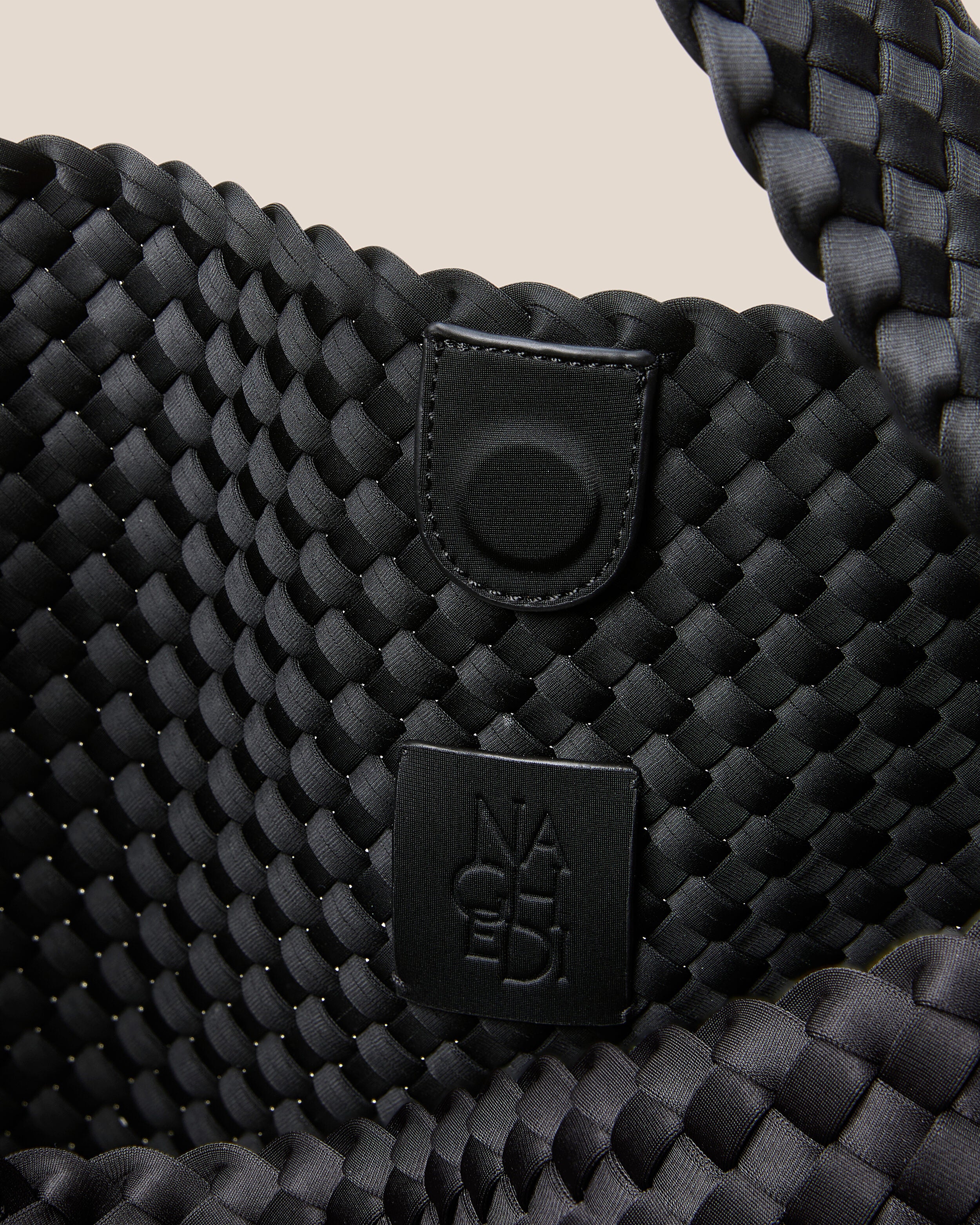 Interior close-up of Nomad Hobo in Onyx showing its open top with magnetic snap closure, and unlined interior.