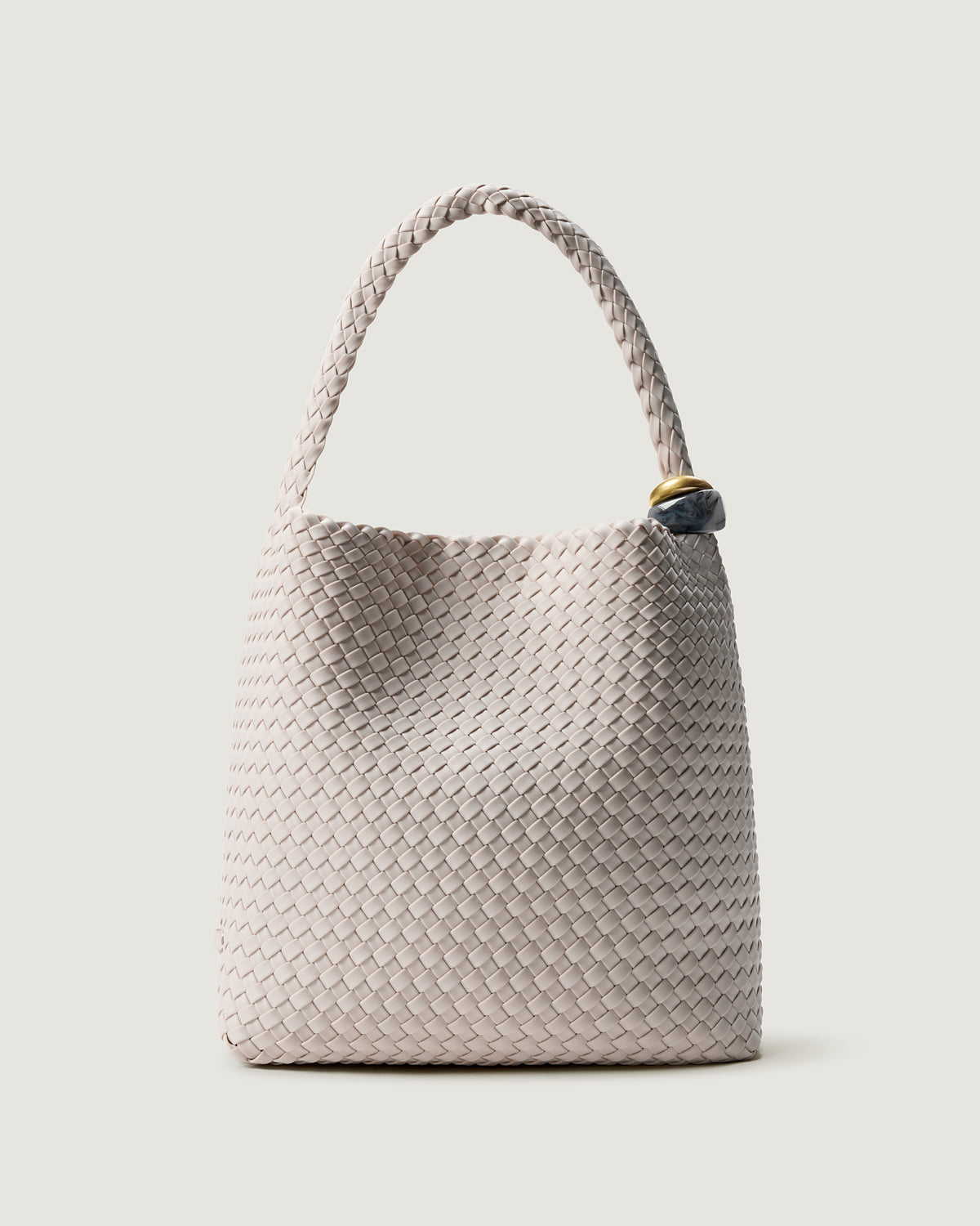 Nomad Hobo in Linen, an ivory tone, in handwoven neoprene, featuring an open top with magnetic snap closure, sculptural bead ornaments, and handwoven shoulder strap.