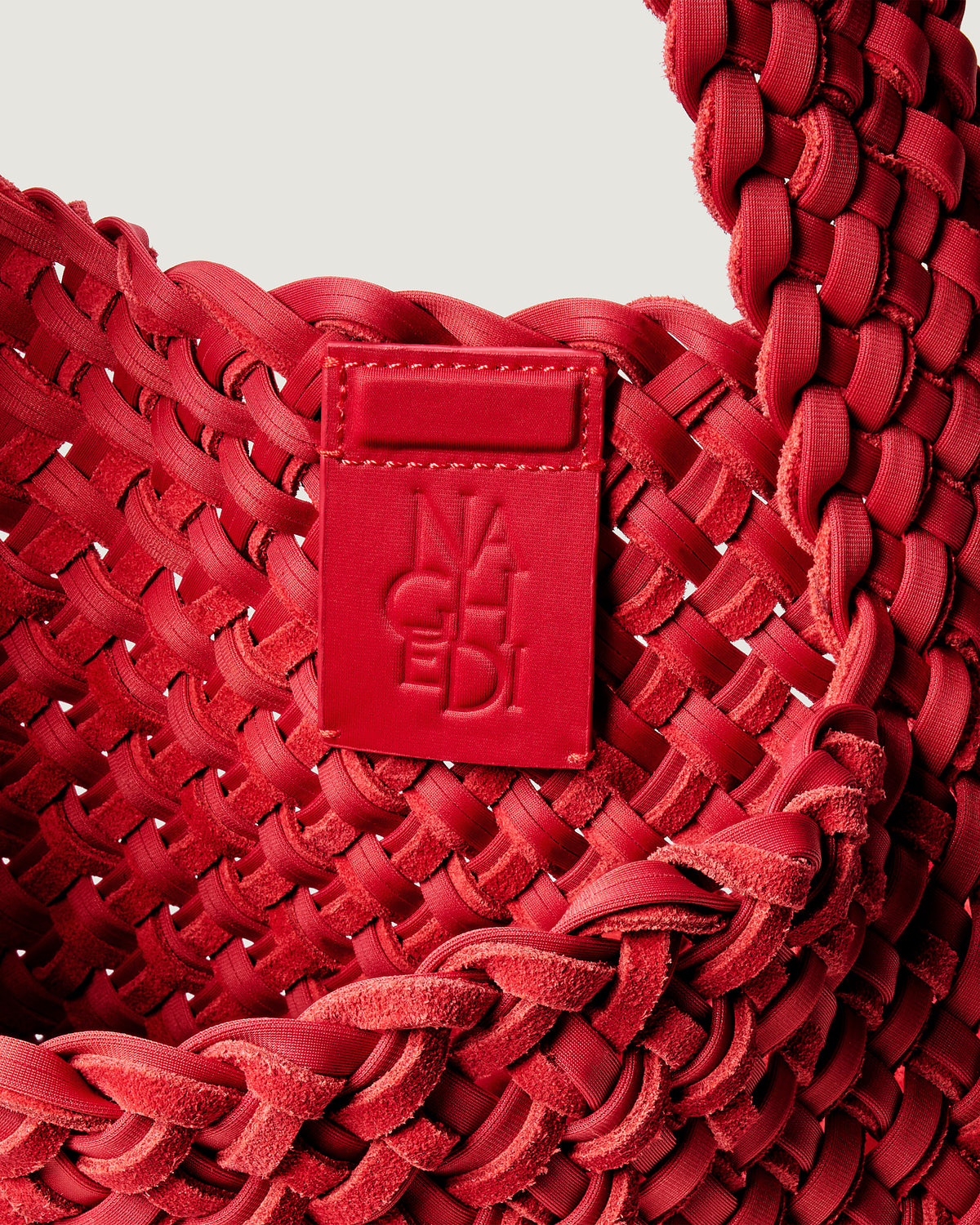 Interior close-up of Nomad Hobo in Cerise suede and neoprene showing its open top with magnetic snap closure, and unlined interior.
