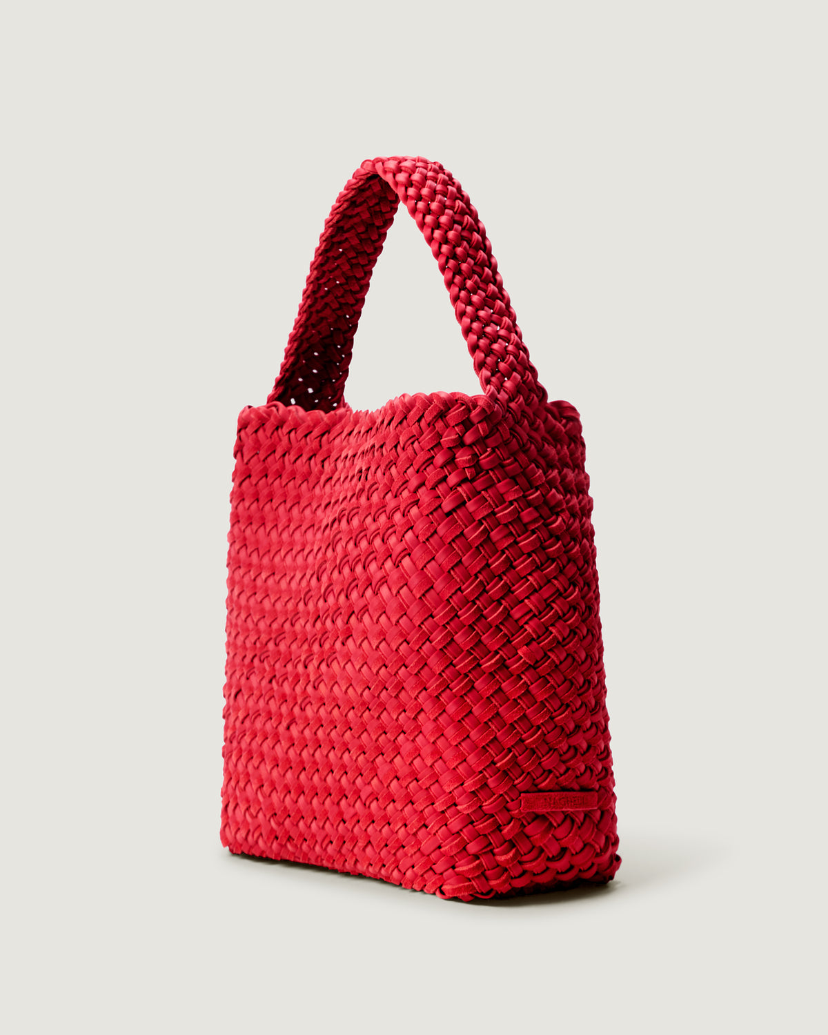 Nomad Medium Hobo in Cerise shown from a side angle, highlighting its handwoven neoprene and suede construction and open top with magnetic snap closure.