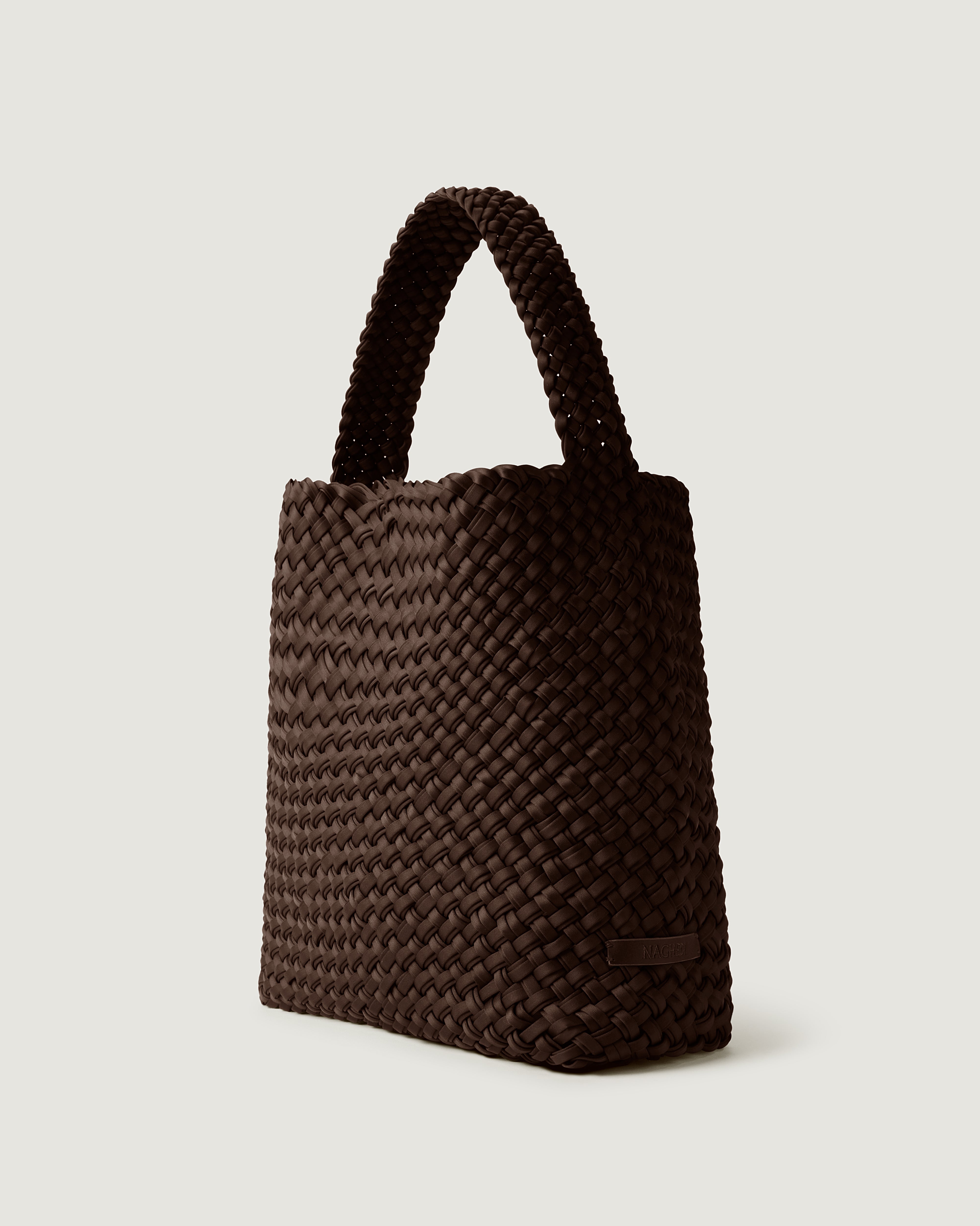 Nomad Hobo in Chocolate shown from a side angle, highlighting its handwoven neoprene construction and open top with magnetic snap closure.