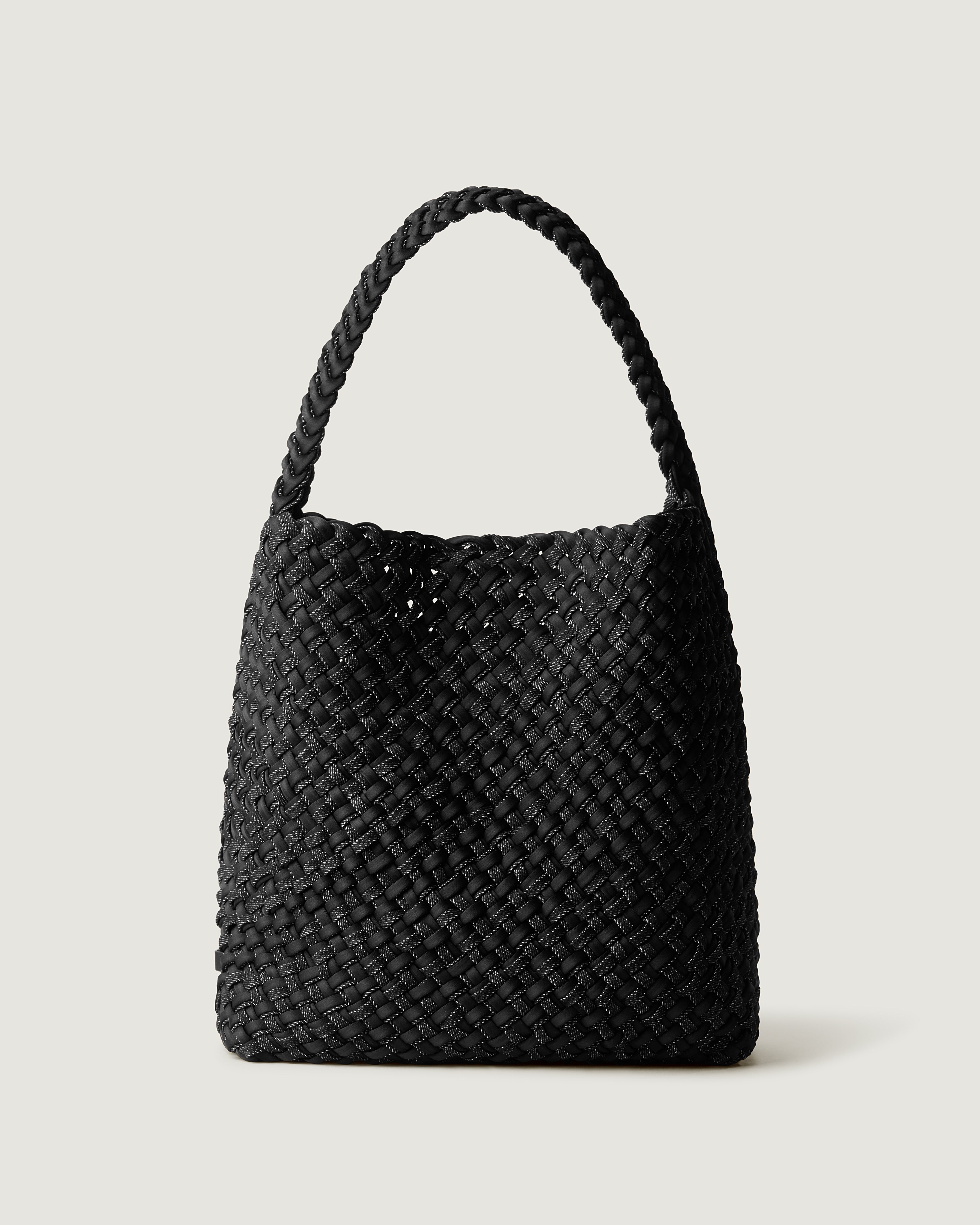 Nomad Hobo in Jet, handwoven in black denim with black neoprene. Features an open top with magnetic snap closure, and handwoven shoulder strap lays comfortably flat.