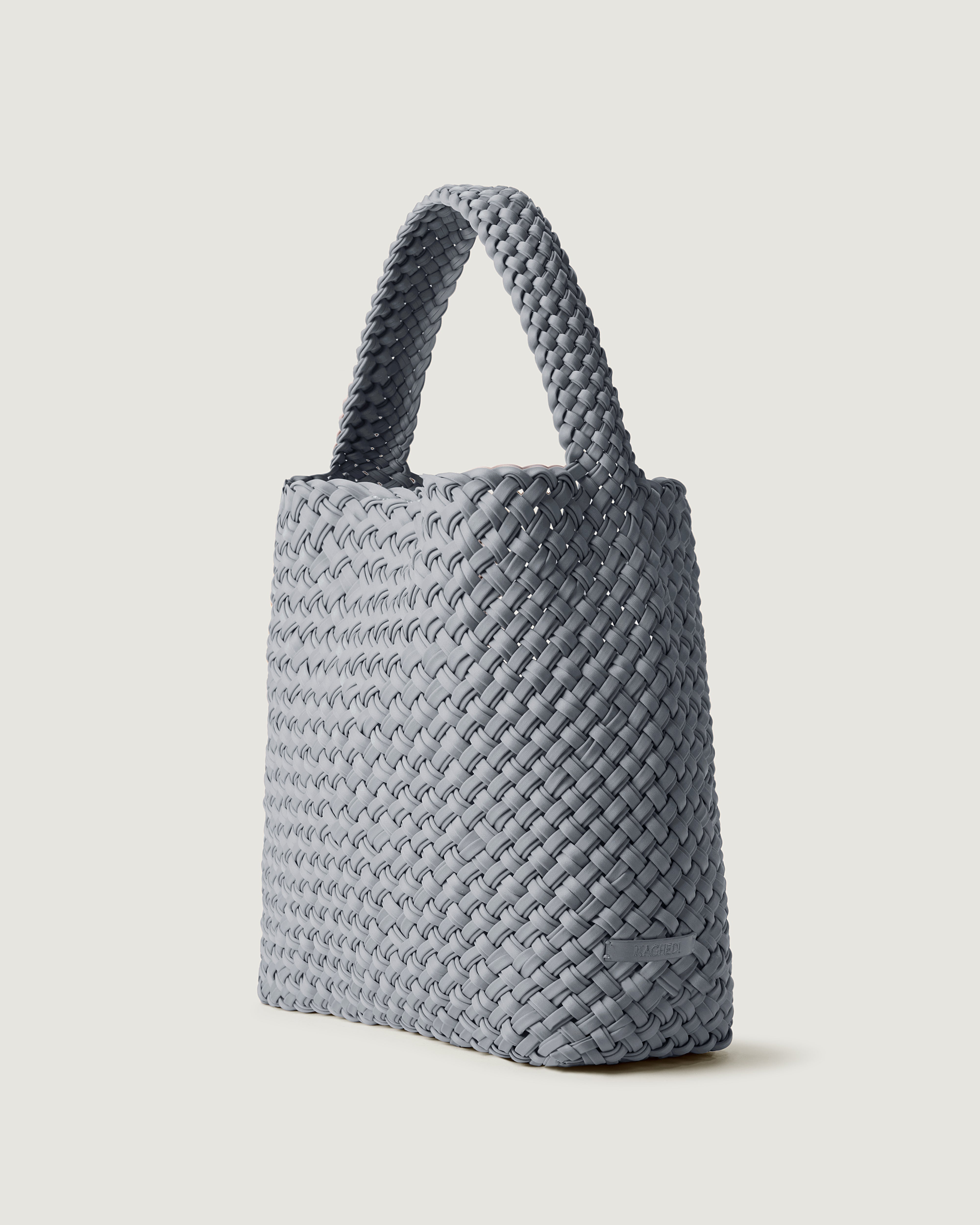 Nomad Hobo in Marina shown from a side angle, highlighting its handwoven neoprene construction and open top with magnetic snap closure.