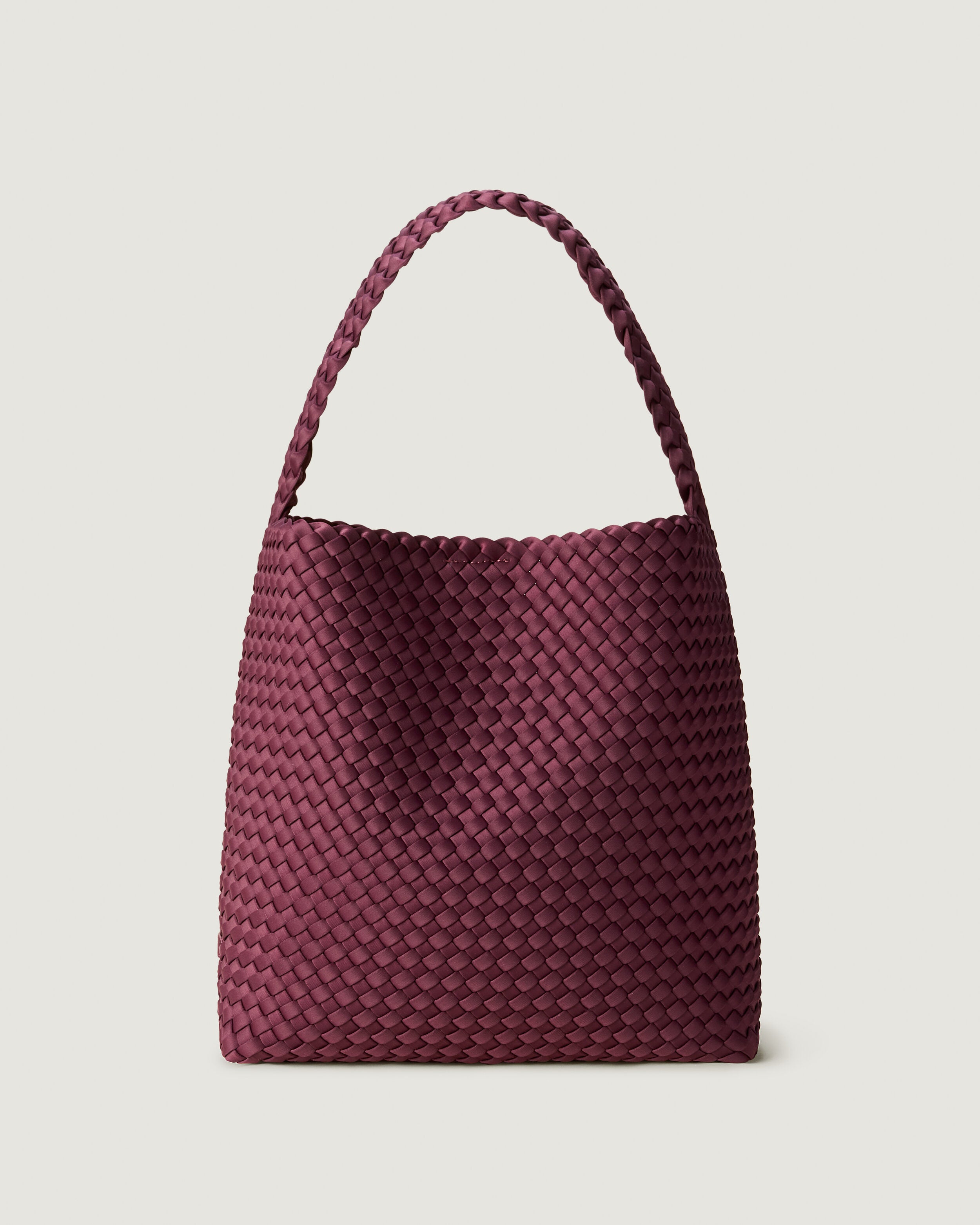 Nomad Hobo in Bordeaux, a rich burgundy tone, in handwoven neoprene, featuring an open top with magnetic snap closure, and handwoven shoulder strap lays comfortably flat.