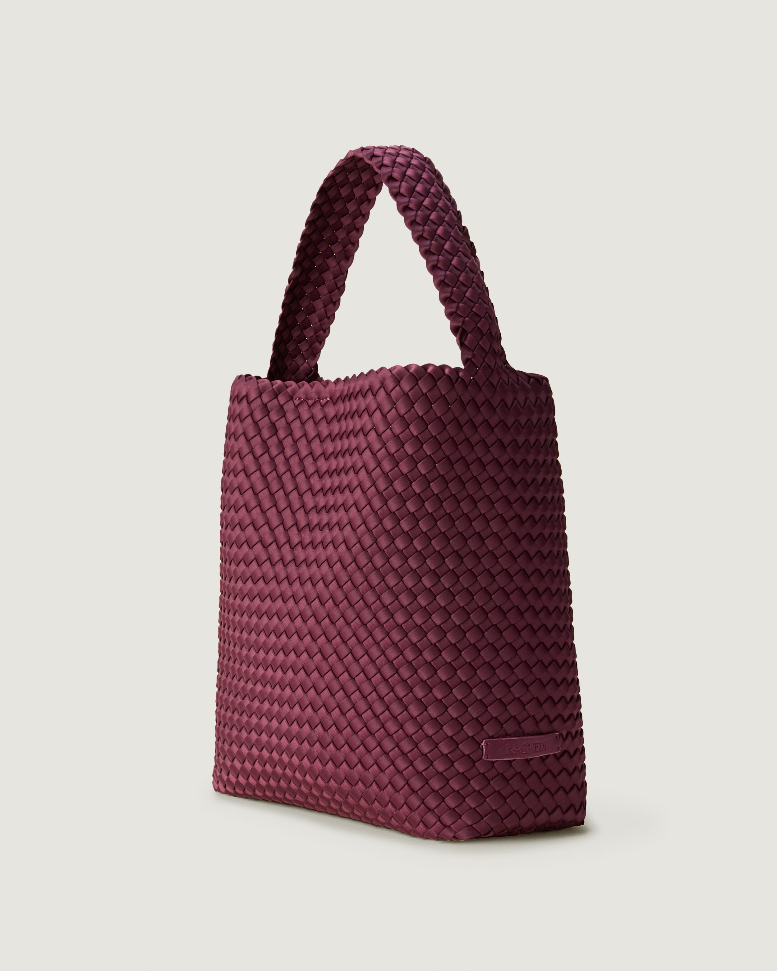 Nomad Hobo in Bordeaux shown from a side angle, highlighting its handwoven neoprene construction and open top with magnetic snap closure.