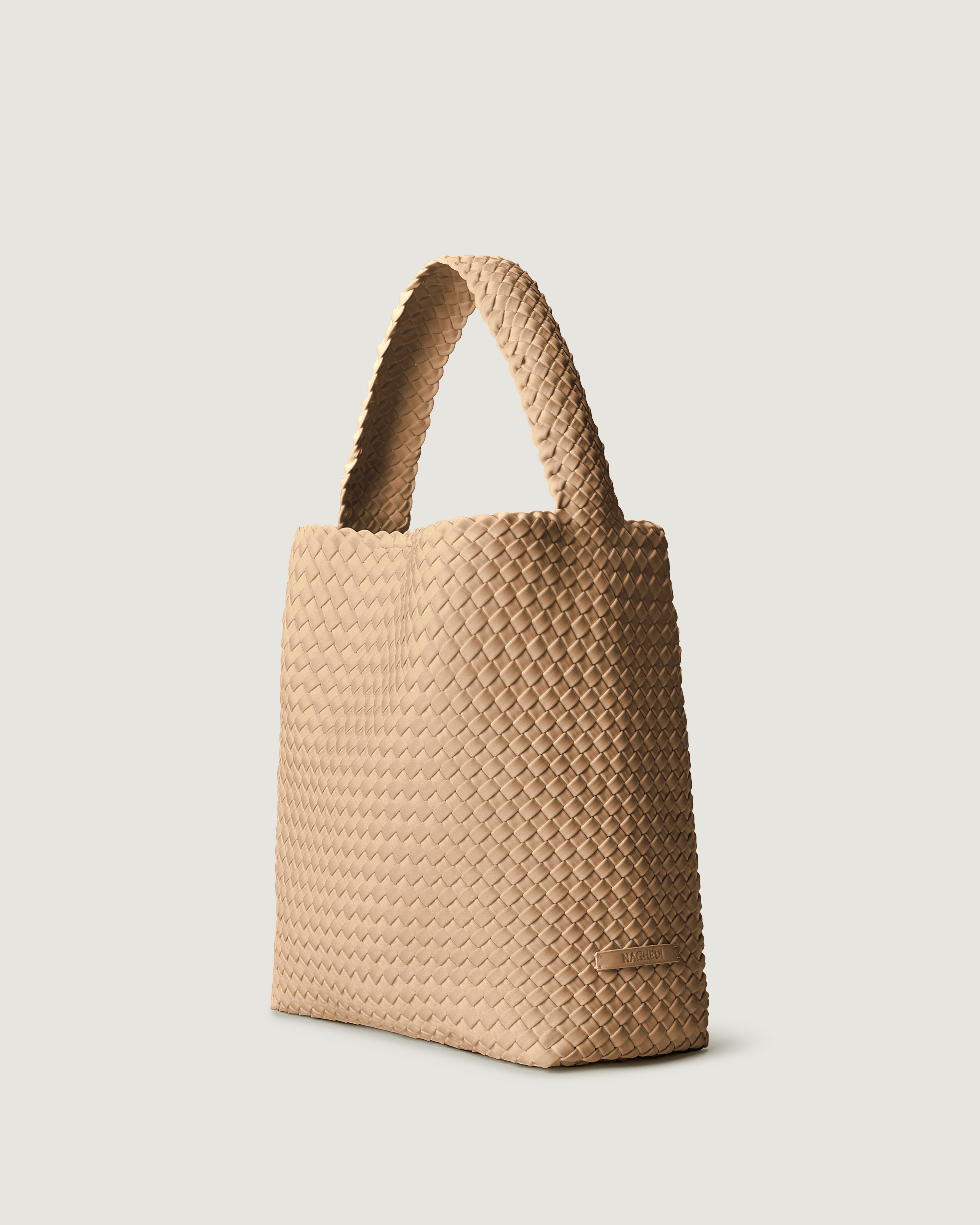 Nomad Hobo in Camel shown from a side angle, highlighting its handwoven neoprene construction and open top with magnetic snap closure.