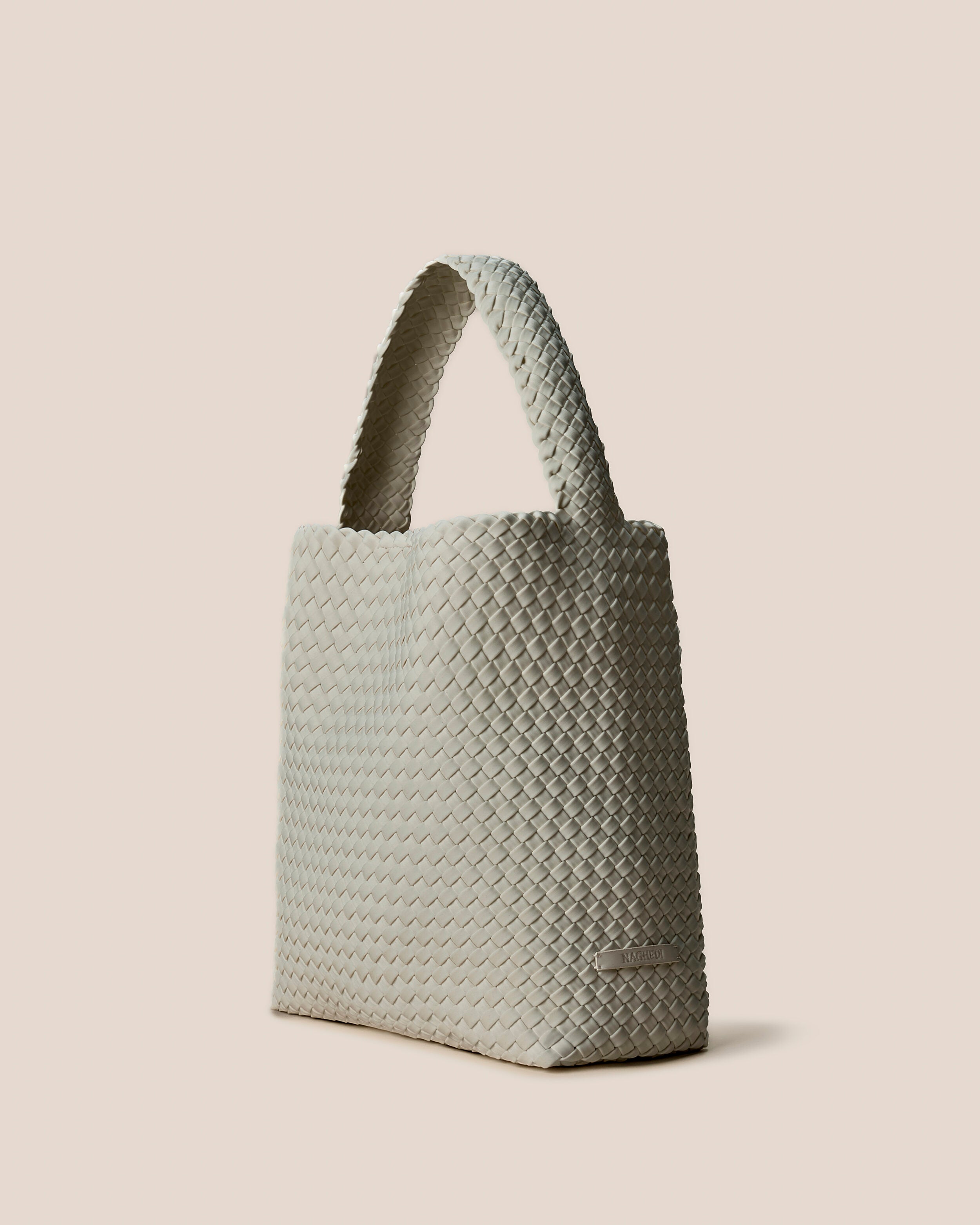 Nomad Hobo in Celadon shown from a side angle, highlighting its handwoven neoprene construction and open top with magnetic snap closure.