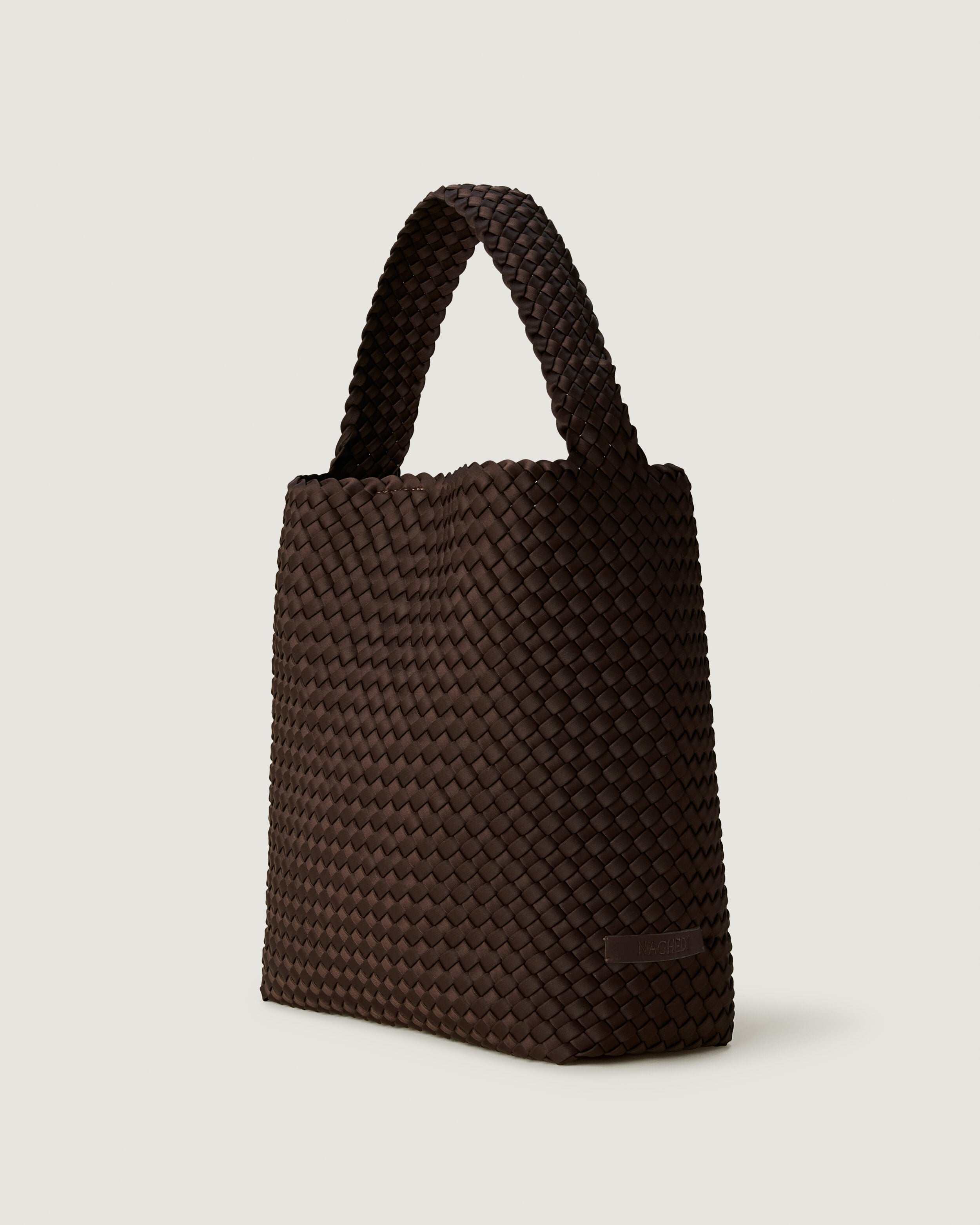 Nomad Hobo in Chocolate shown from a side angle, highlighting its handwoven neoprene construction and open top with magnetic snap closure.