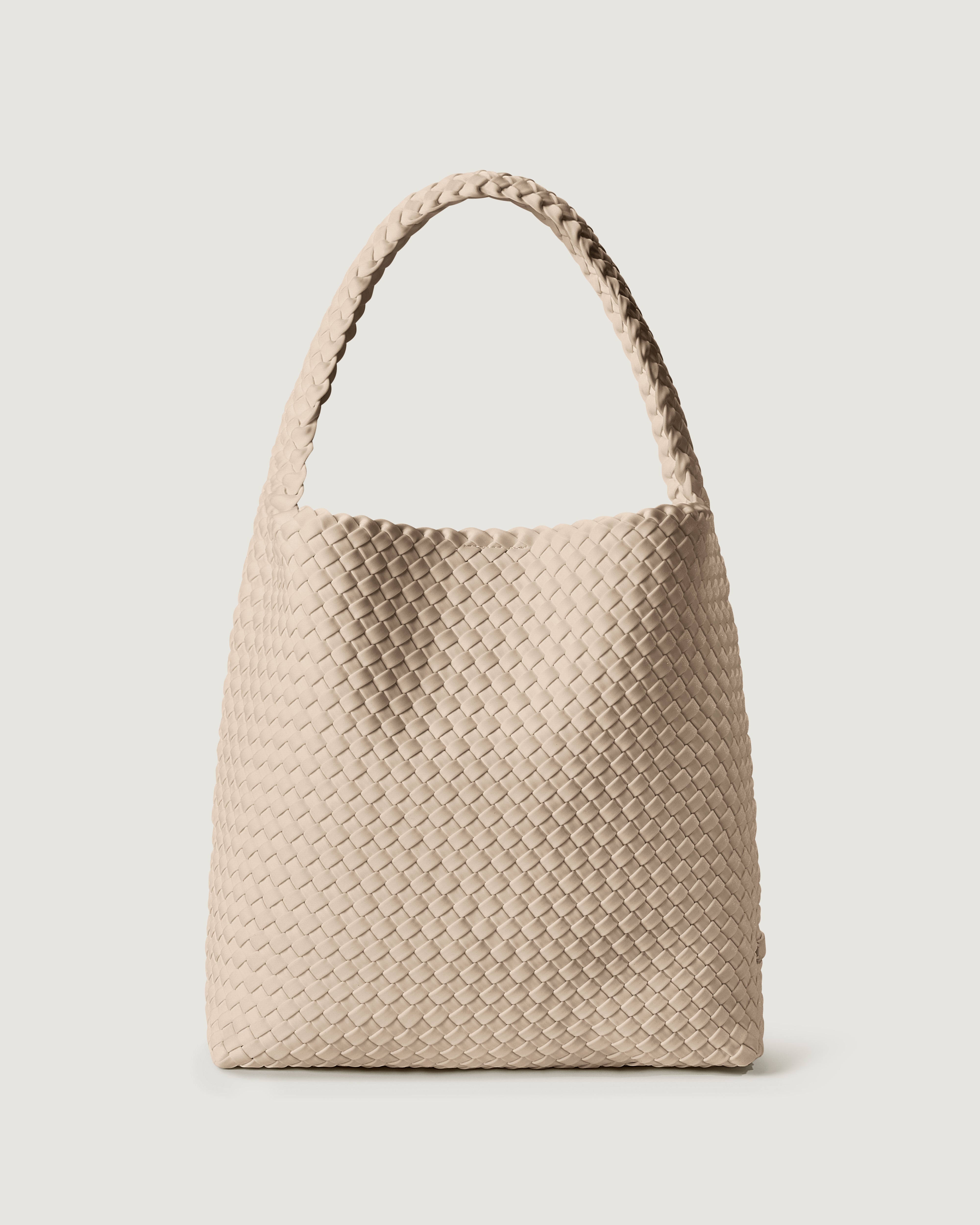 Nomad Hobo in Ecru, a cream tone, in handwoven neoprene, featuring an open top with magnetic snap closure, and handwoven shoulder strap lays comfortably flat.