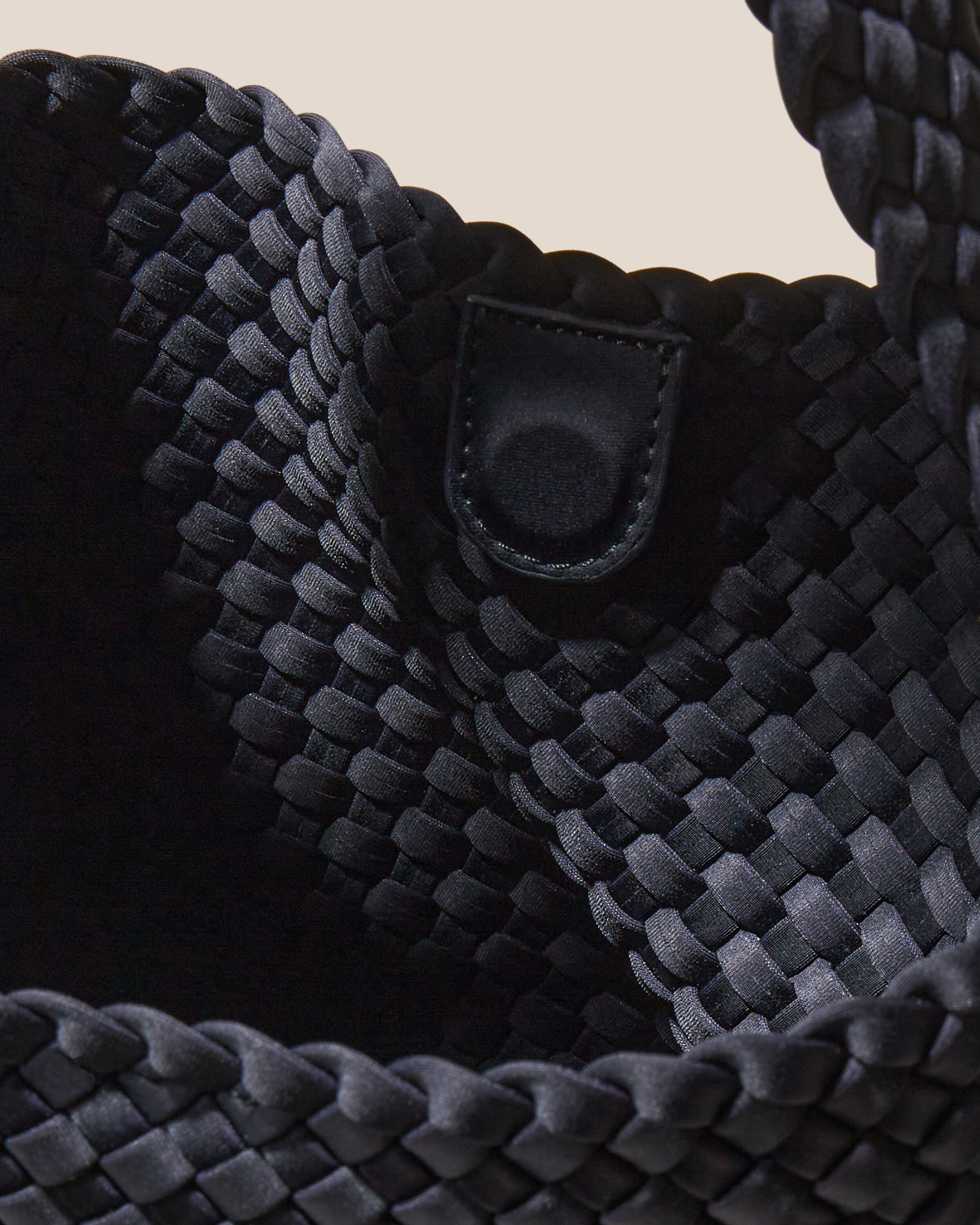 Interior close-up of Nomad Hobo in Onyx showing its open top with magnetic snap closure, and unlined interior.