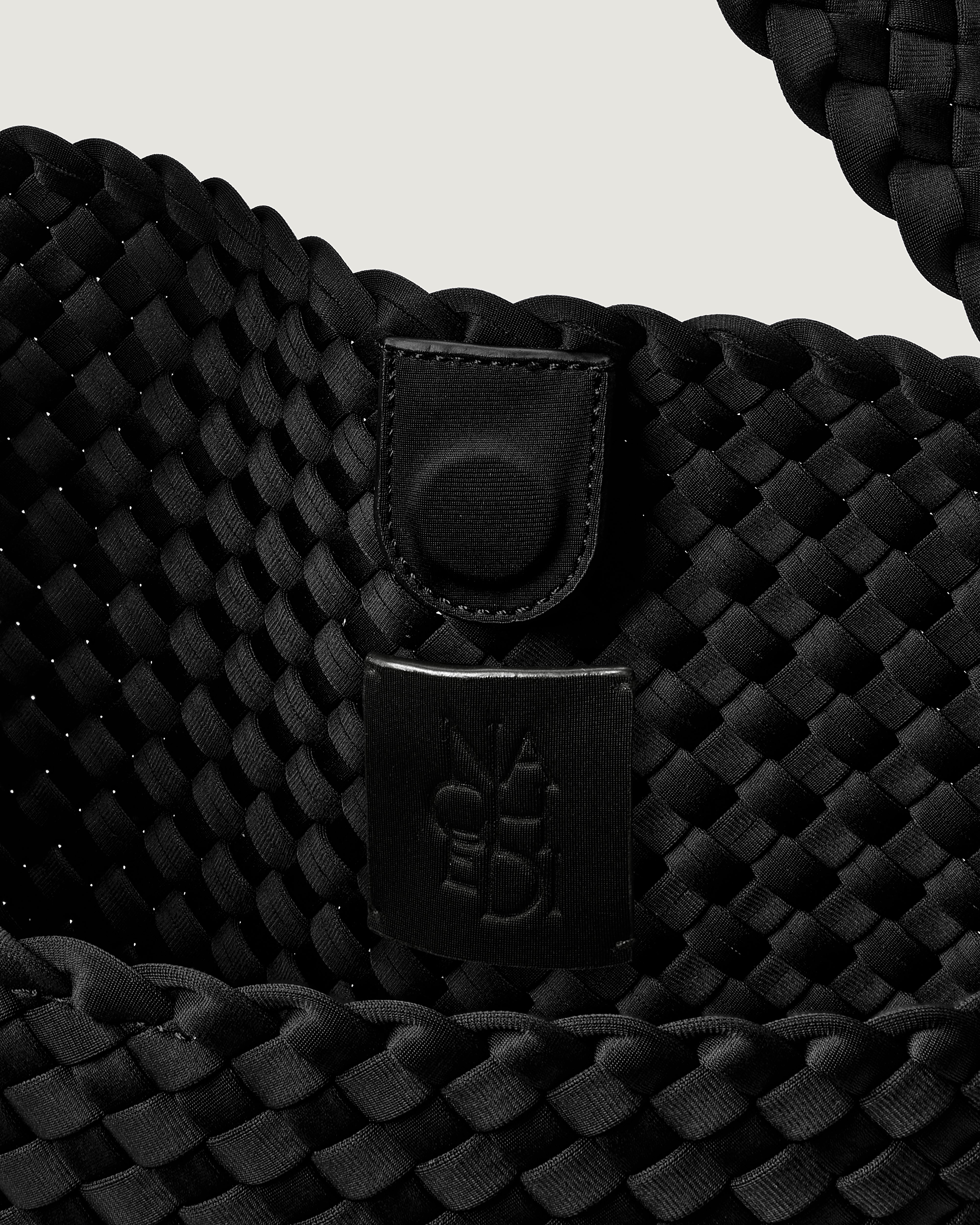 Interior close-up of Nomad Hobo in Onyx showing its open top with magnetic snap closure, and unlined interior.