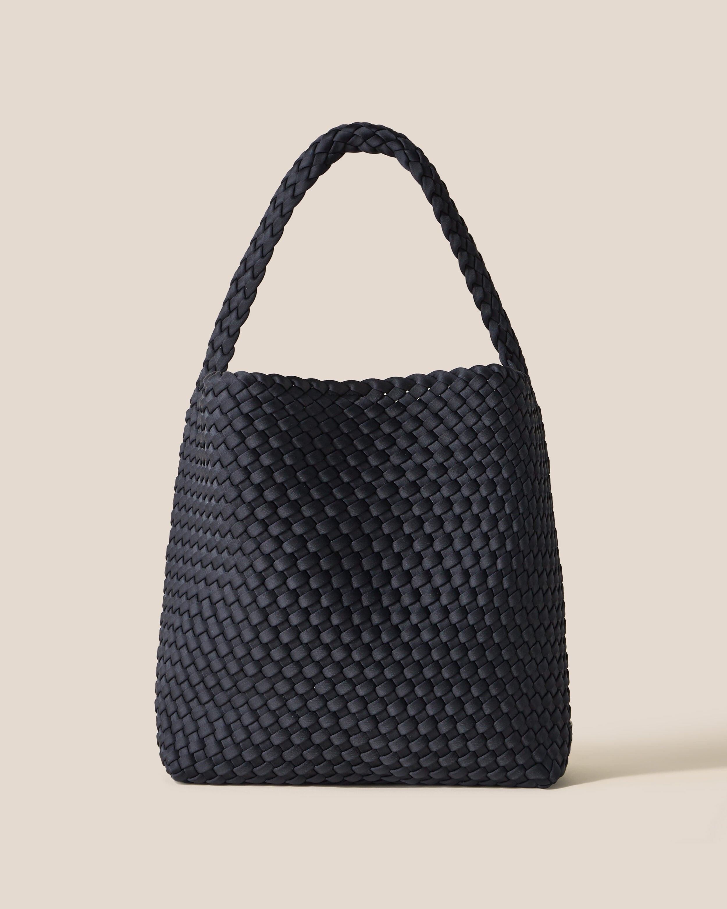 Nomad Hobo in Onyx, a true black tone, in handwoven neoprene, featuring an open top with magnetic snap closure, and handwoven shoulder strap lays comfortably flat.