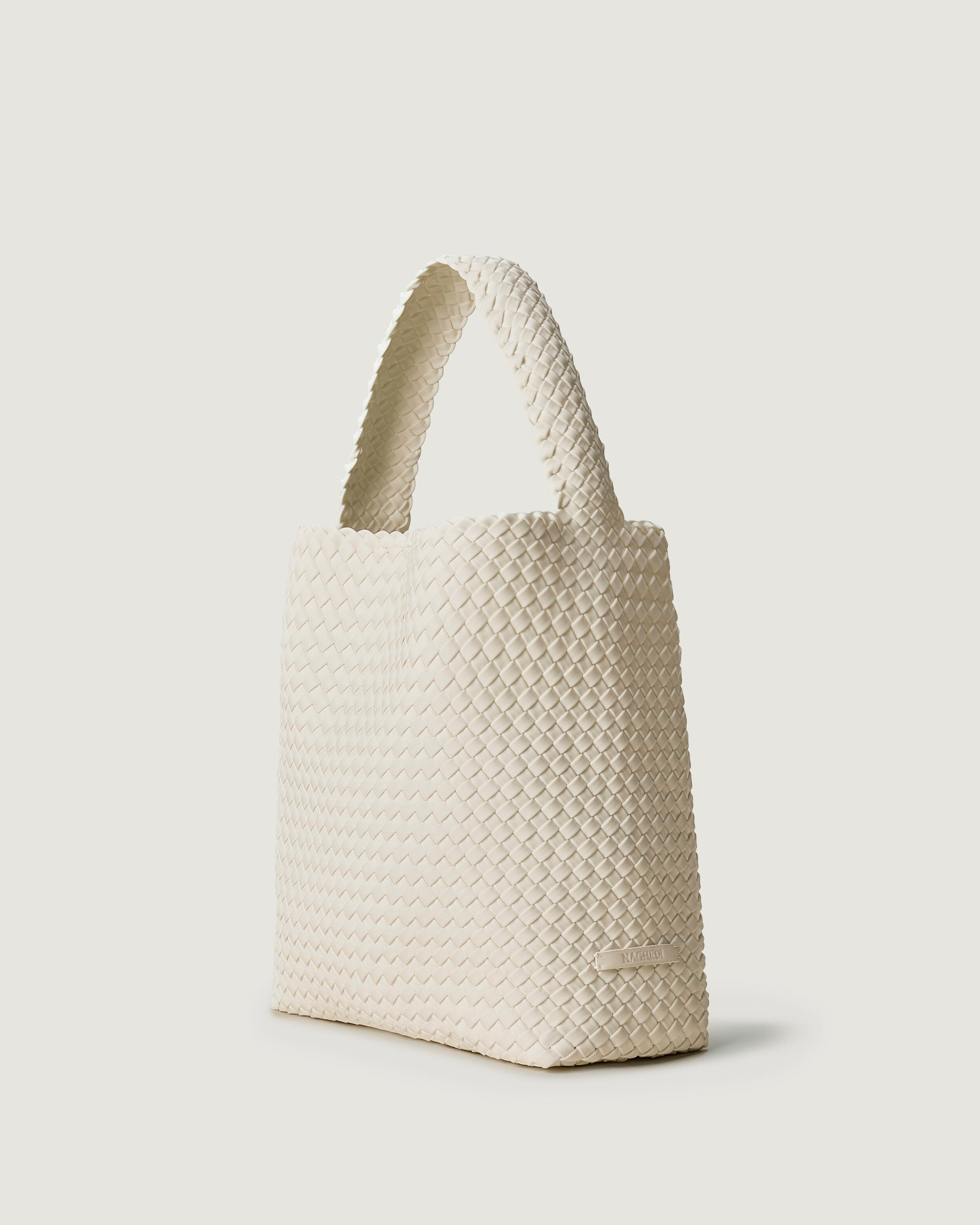 Nomad Hobo in Salt shown from a side angle, highlighting its handwoven neoprene construction and open top with magnetic snap closure.
