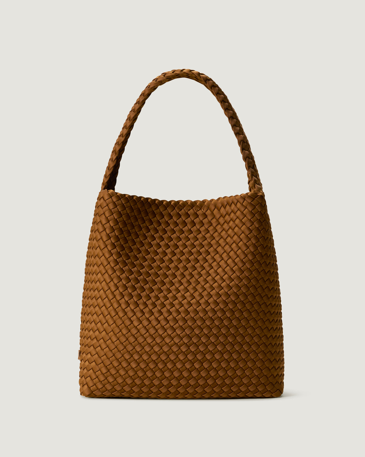 Nomad Hobo in Teak, a saddle brown tone, in handwoven neoprene, featuring an open top with magnetic snap closure, and handwoven shoulder strap lays comfortably flat.