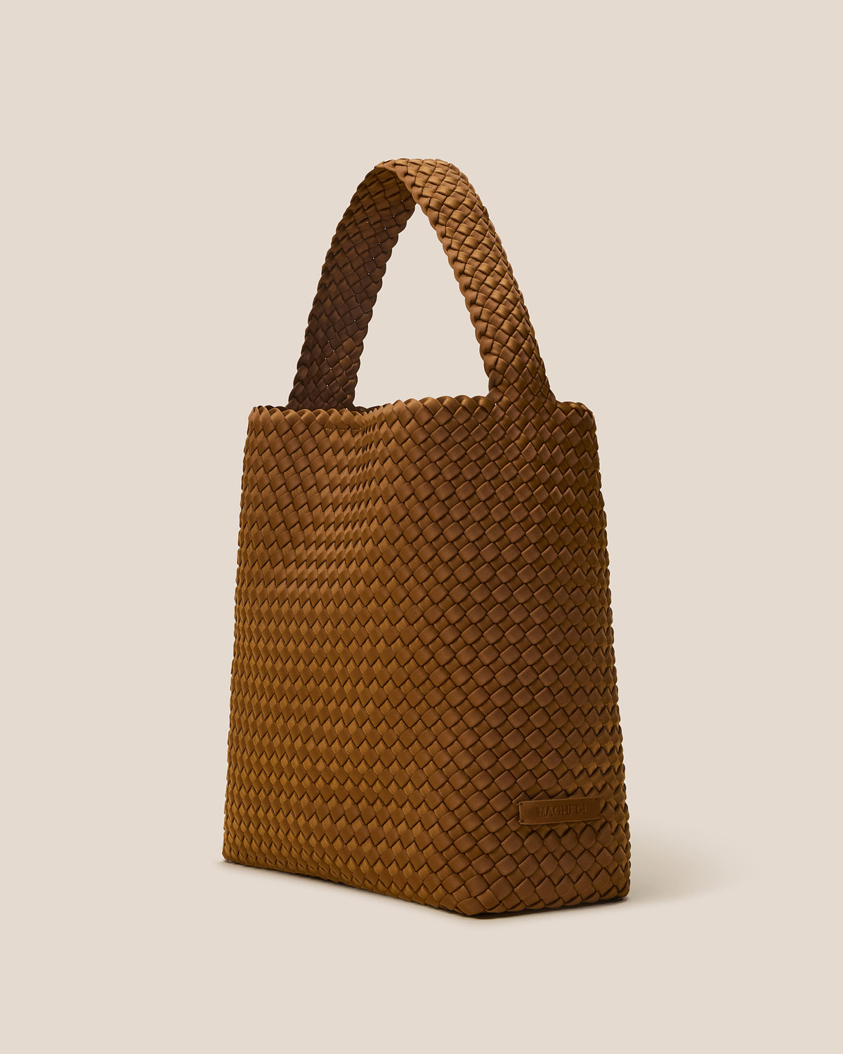 Nomad Hobo in Teak shown from a side angle, highlighting its handwoven neoprene construction and open top with magnetic snap closure.