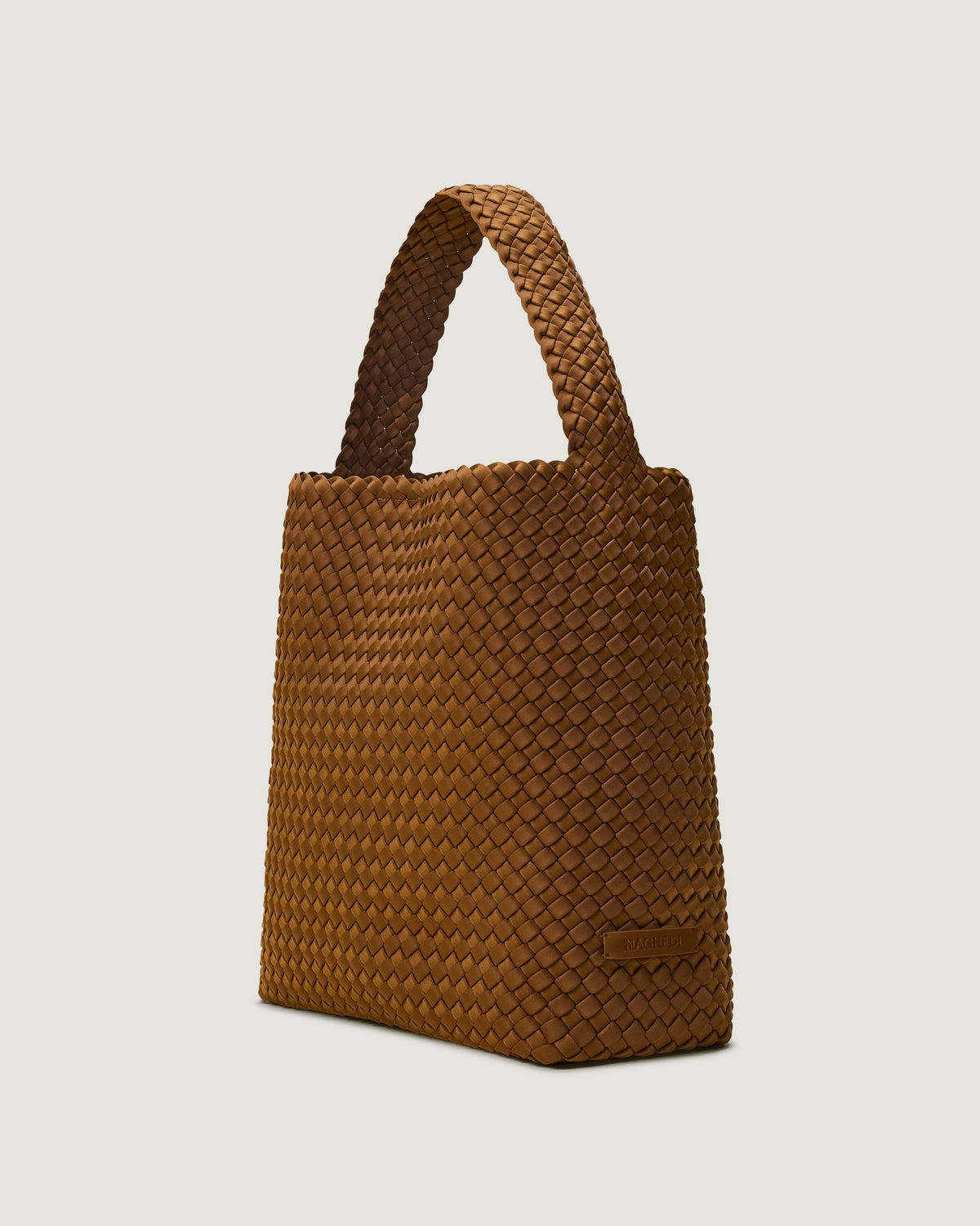 Nomad Hobo in Teak shown from a side angle, highlighting its handwoven neoprene construction and open top with magnetic snap closure.