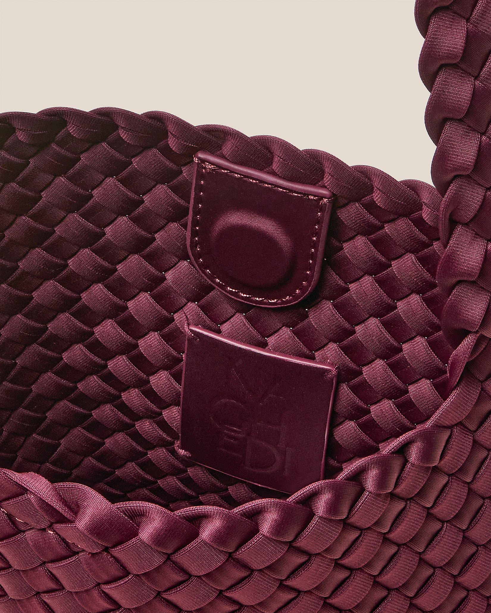 Interior close-up of Nomad Small Hobo Bag in Bordeaux showing its open top with magnetic snap closure, and unlined interior.