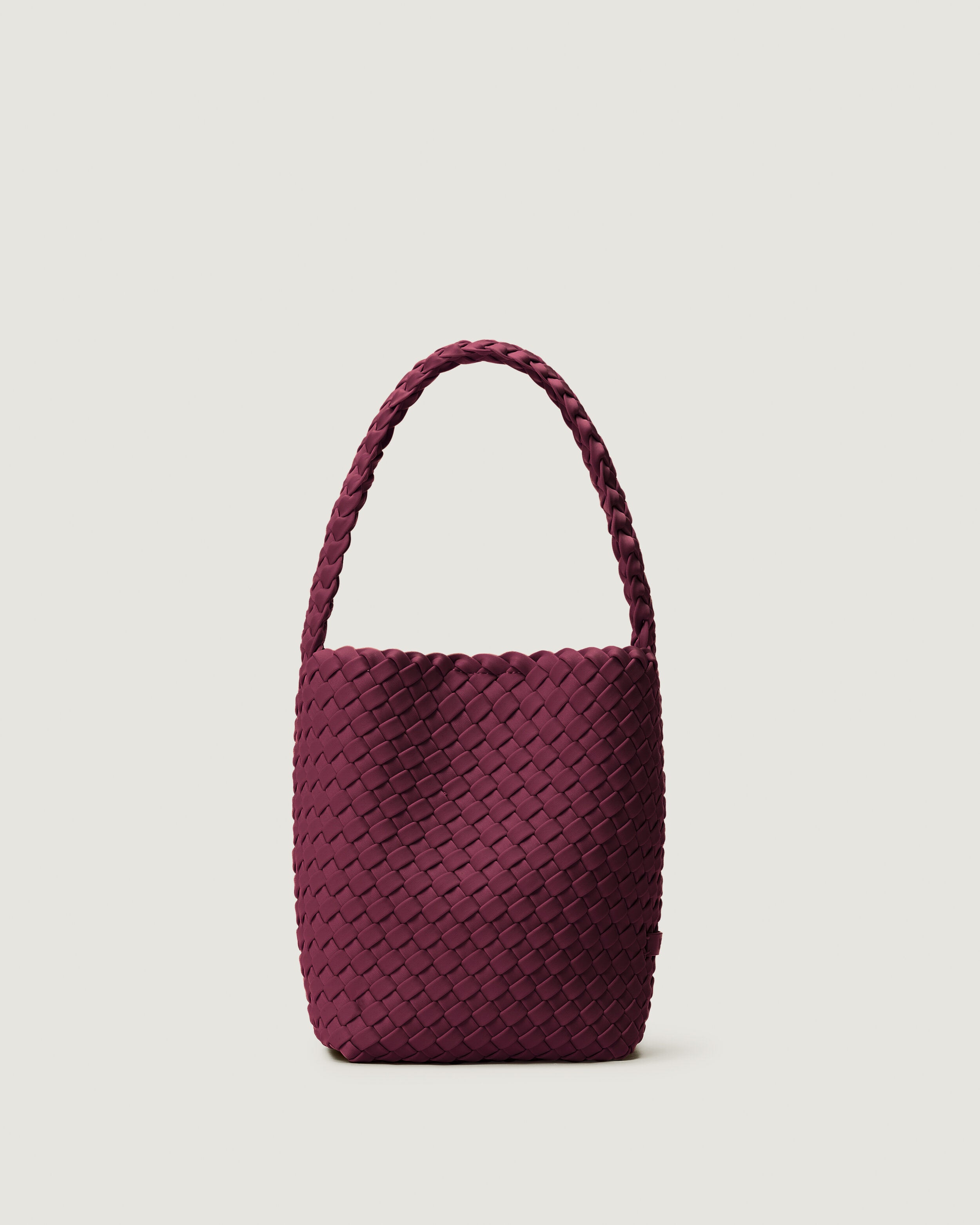 Nomad Hobo in Bordeaux, a rich burgundy tone, in handwoven neoprene, featuring an open top with magnetic snap closure, and handwoven shoulder strap lays comfortably flat.