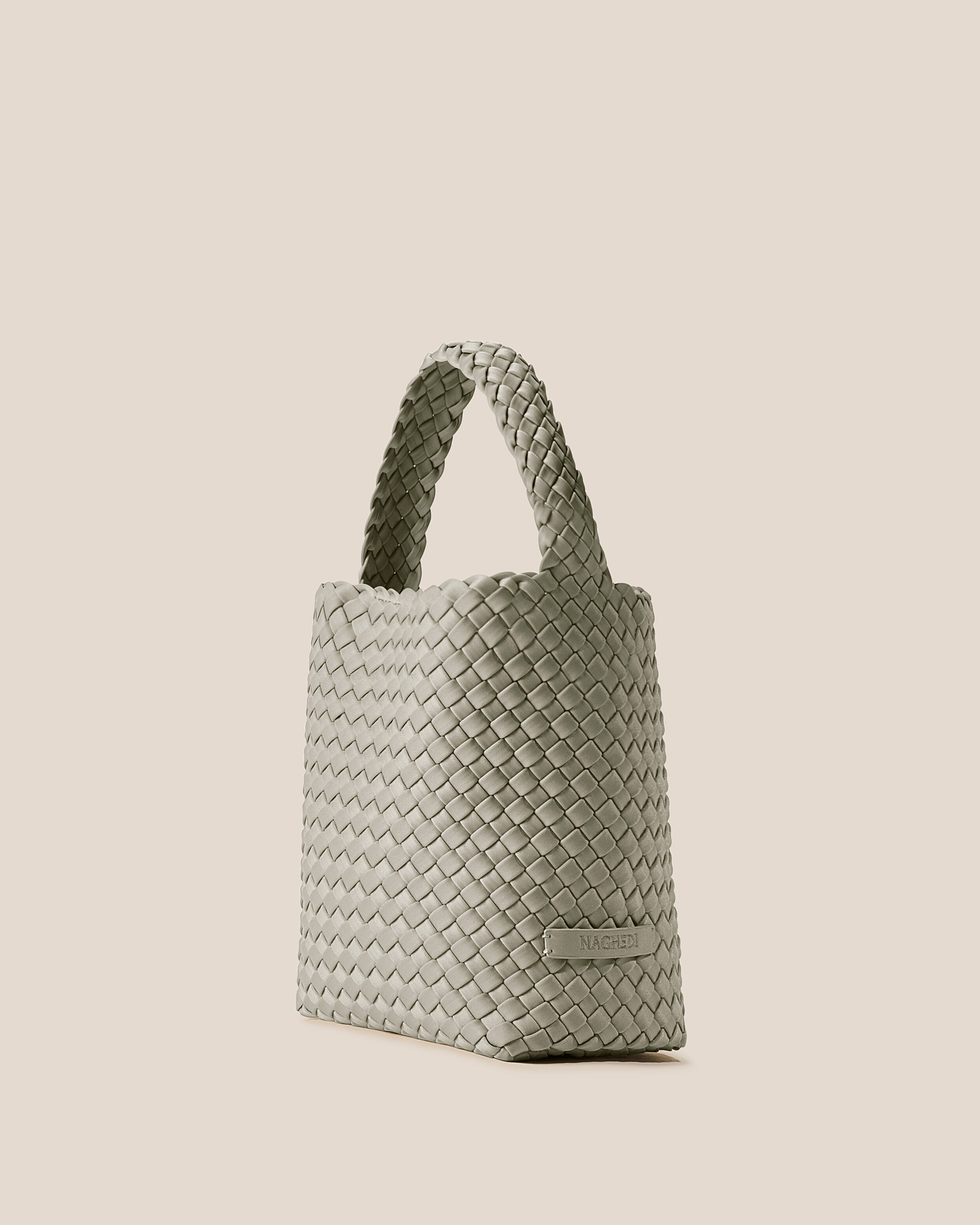 Nomad Hobo in Celadon shown from a side angle, highlighting its handwoven neoprene construction and open top with magnetic snap closure.