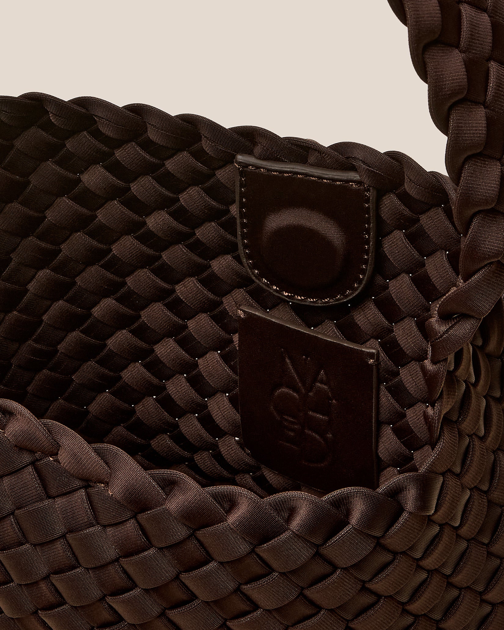 Interior close-up of Nomad Small Hobo Bag in Chocolate showing its open top with magnetic snap closure, and unlined interior.