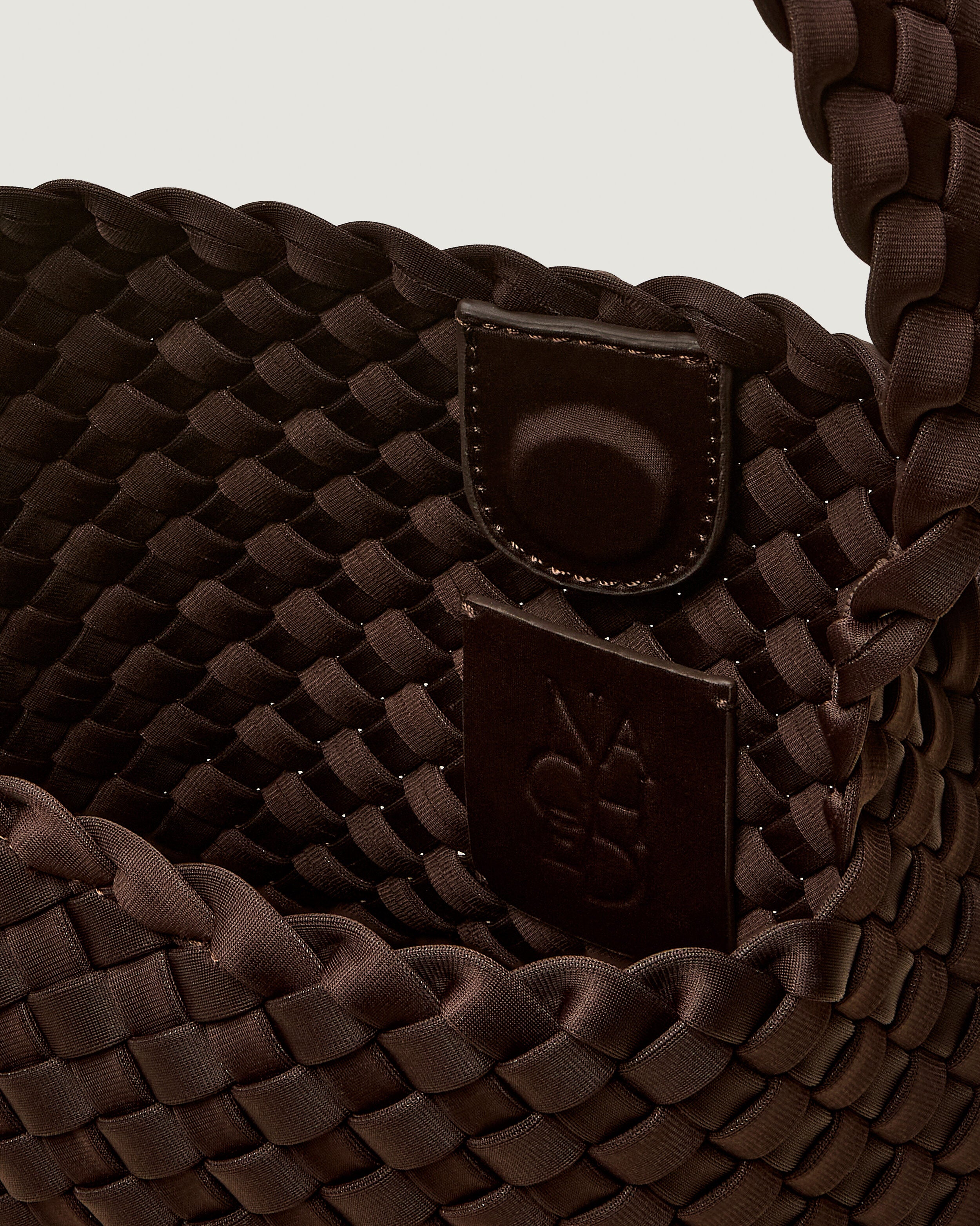 Interior close-up of Nomad Hobo in Chocolate showing its open top with magnetic snap closure, and unlined interior.