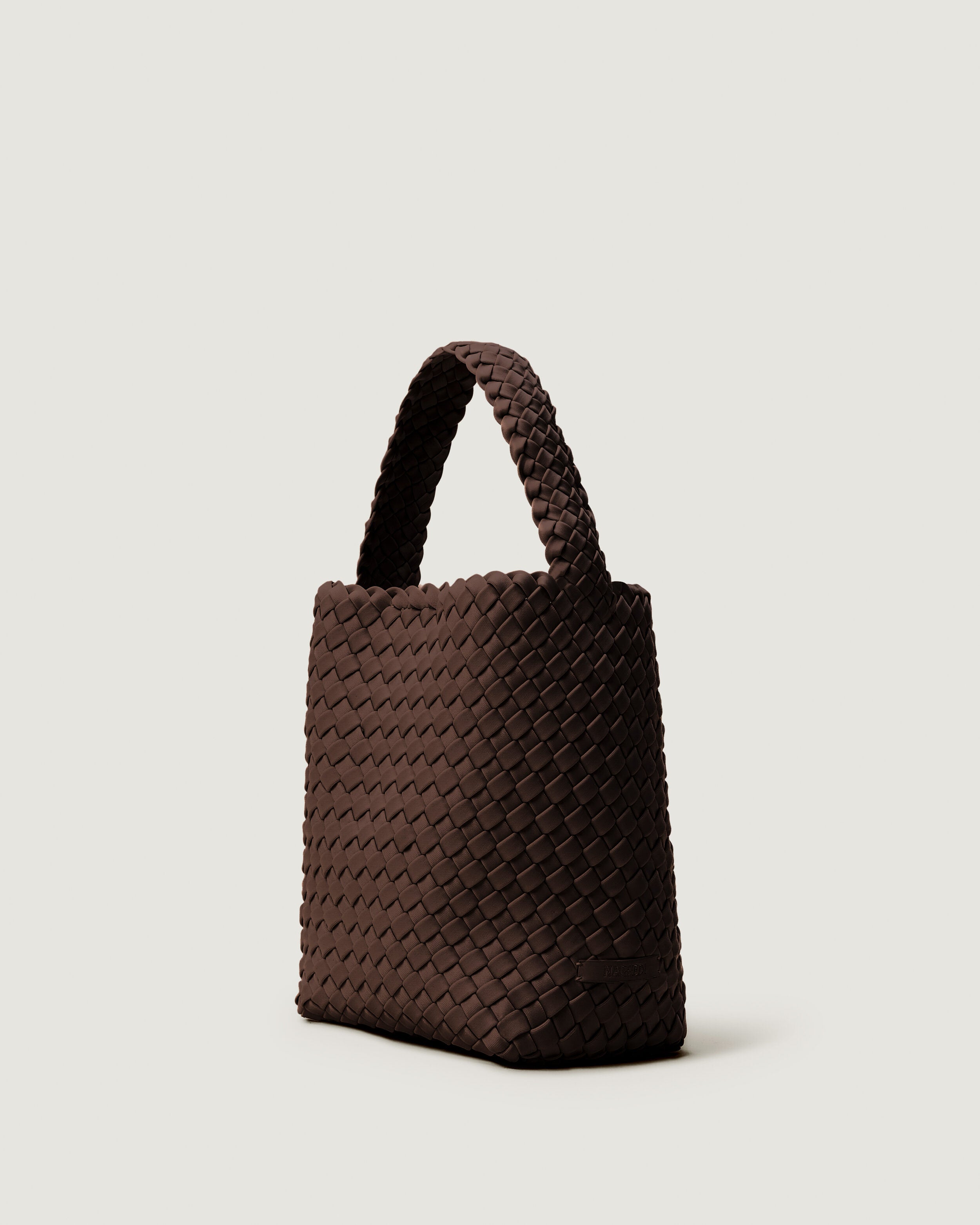 Nomad Hobo in Chocolate shown from a side angle, highlighting its handwoven neoprene construction and open top with magnetic snap closure.