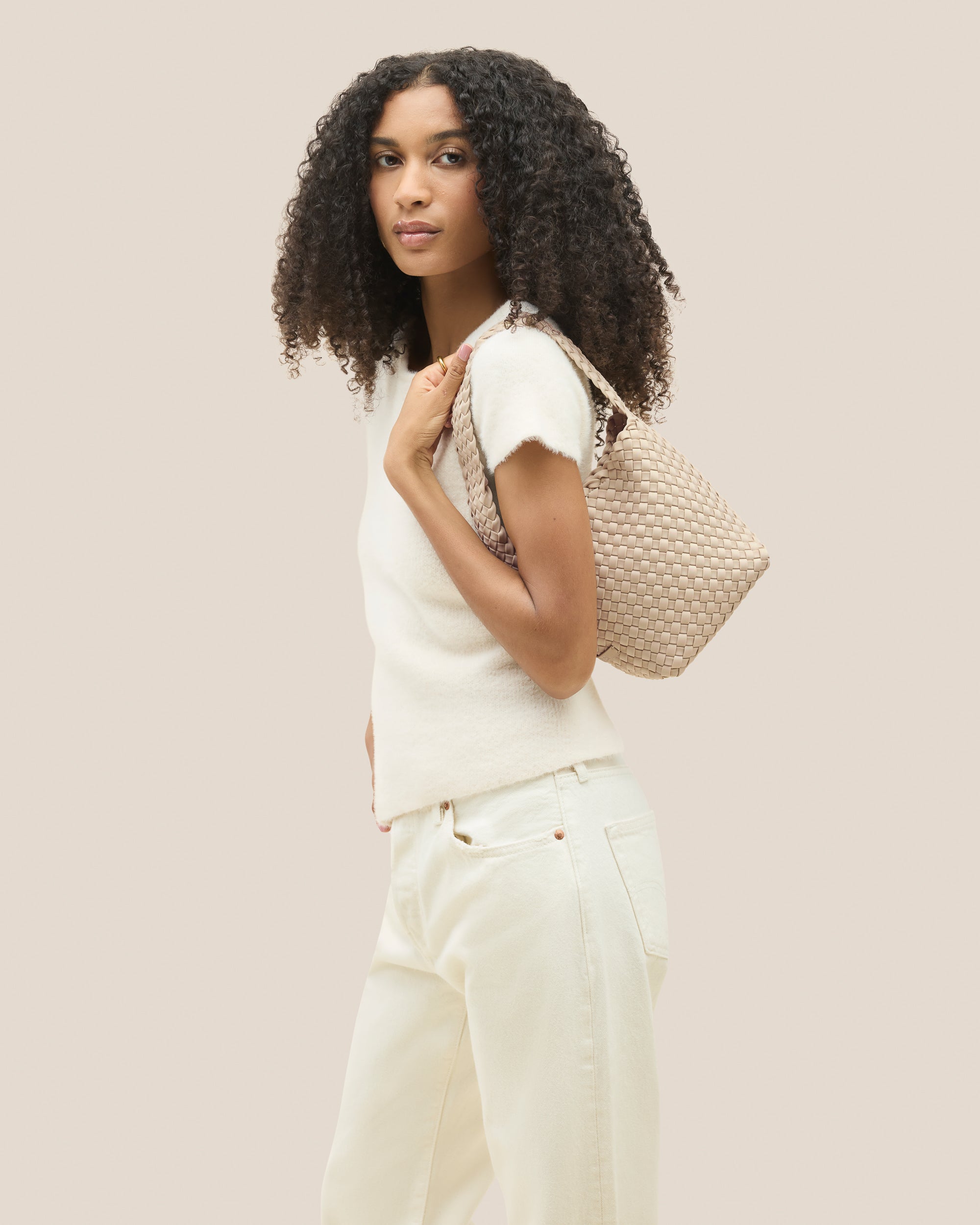 Nomad Small Hobo Bag in Ecru shown on model to illustrate scale and soft silhouette.