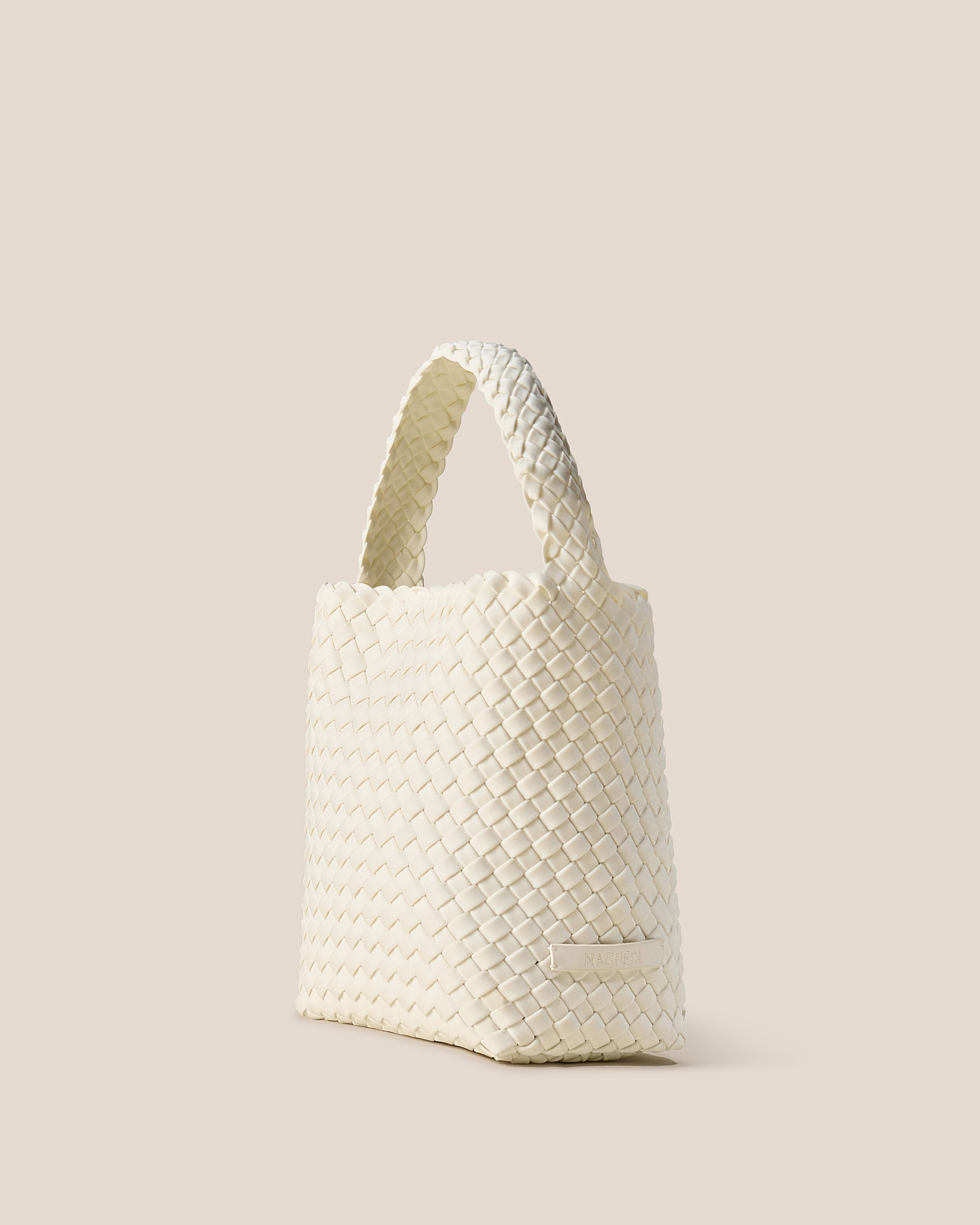 Nomad Hobo in Jasmine shown from a side angle, highlighting its handwoven neoprene construction and open top with magnetic snap closure.