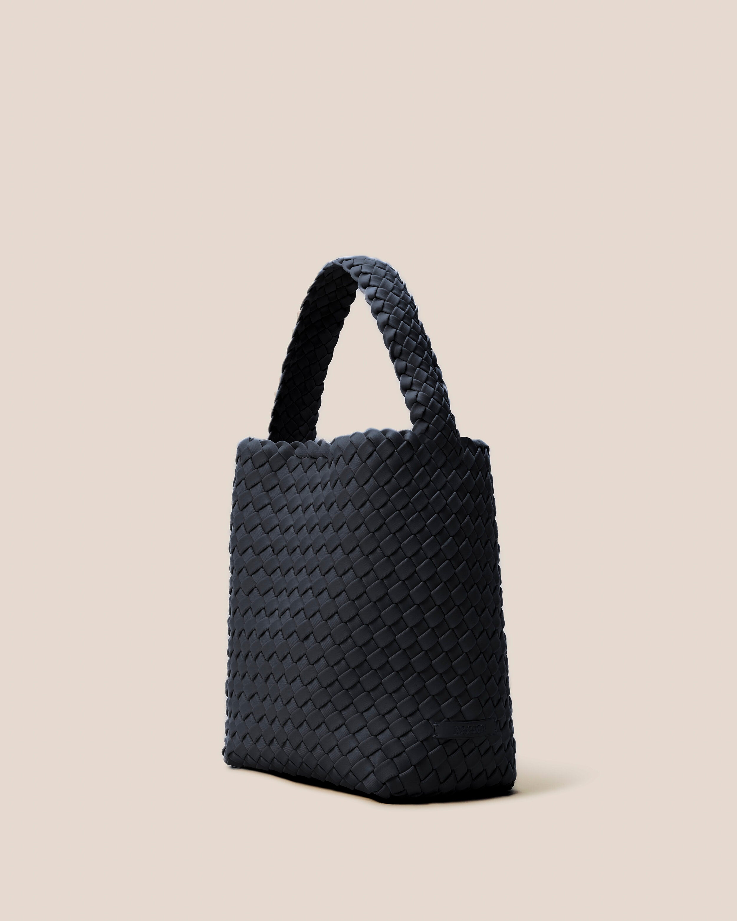 Nomad Hobo in Onyx shown from a side angle, highlighting its handwoven neoprene construction and open top with magnetic snap closure.