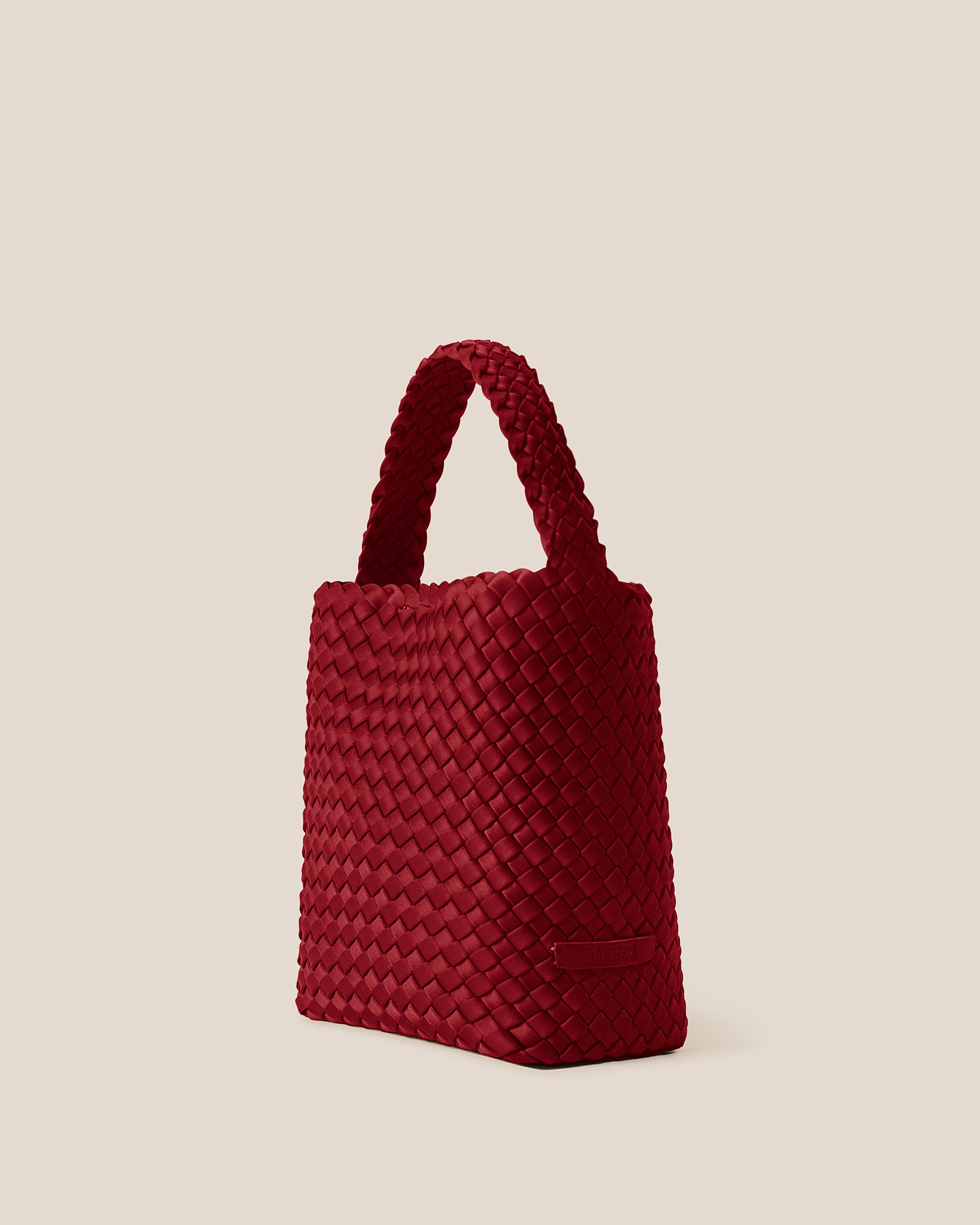 Nomad Hobo in Rosso shown from a side angle, highlighting its handwoven neoprene construction and open top with magnetic snap closure.