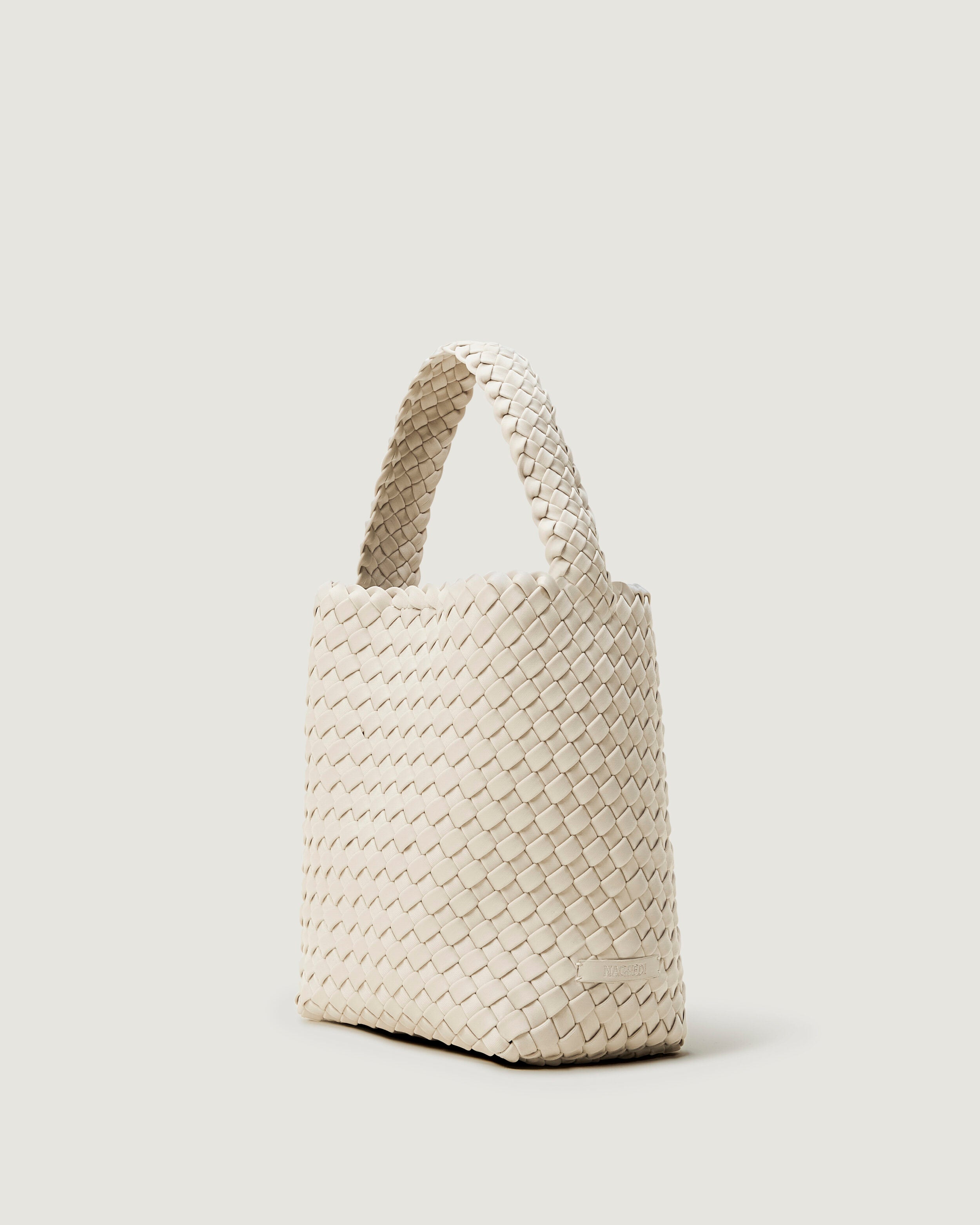 Nomad Hobo in Salt shown from a side angle, highlighting its handwoven neoprene construction and open top with magnetic snap closure.