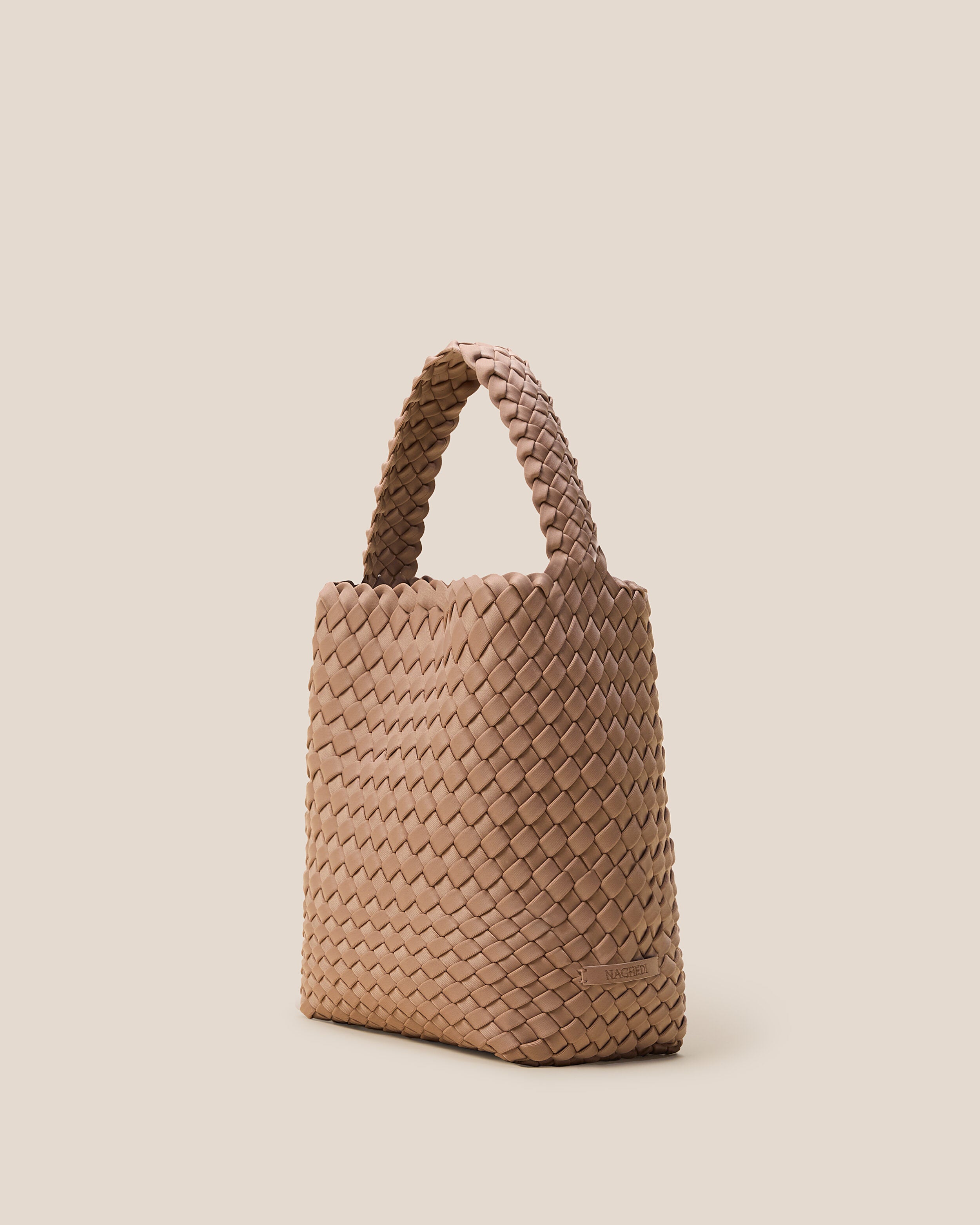 Nomad Hobo in Seychelles shown from a side angle, highlighting its handwoven neoprene construction and open top with magnetic snap closure.