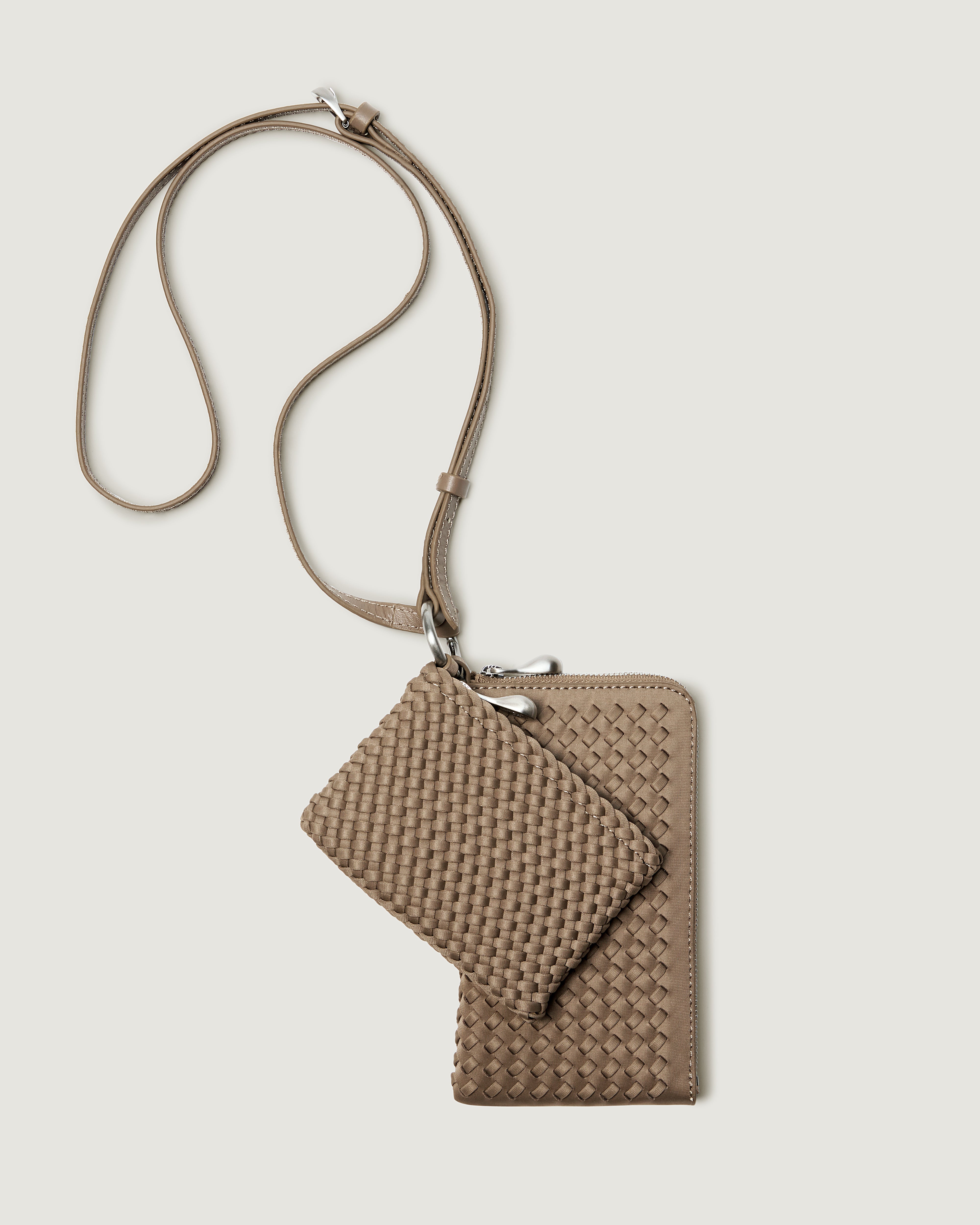A handwoven neoprene crossbody zippered phone case in a taupe-brown color, featuring a matching zippered card holder pouch and a thin adjustable shoulder strap.