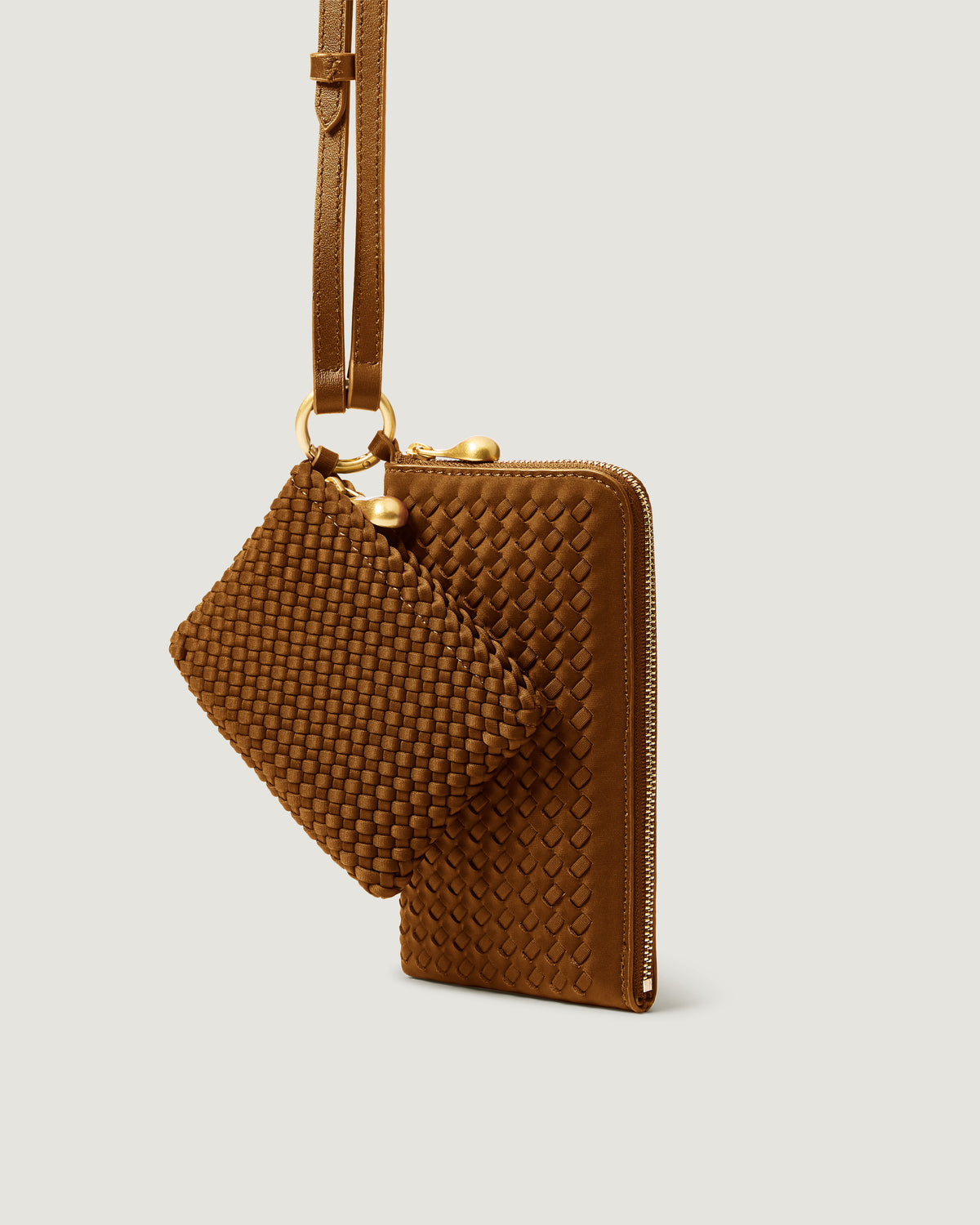 A handwoven neoprene crossbody zippered phone case in a saddle brown color, featuring a matching zippered card holder pouch and a thin adjustable shoulder strap.