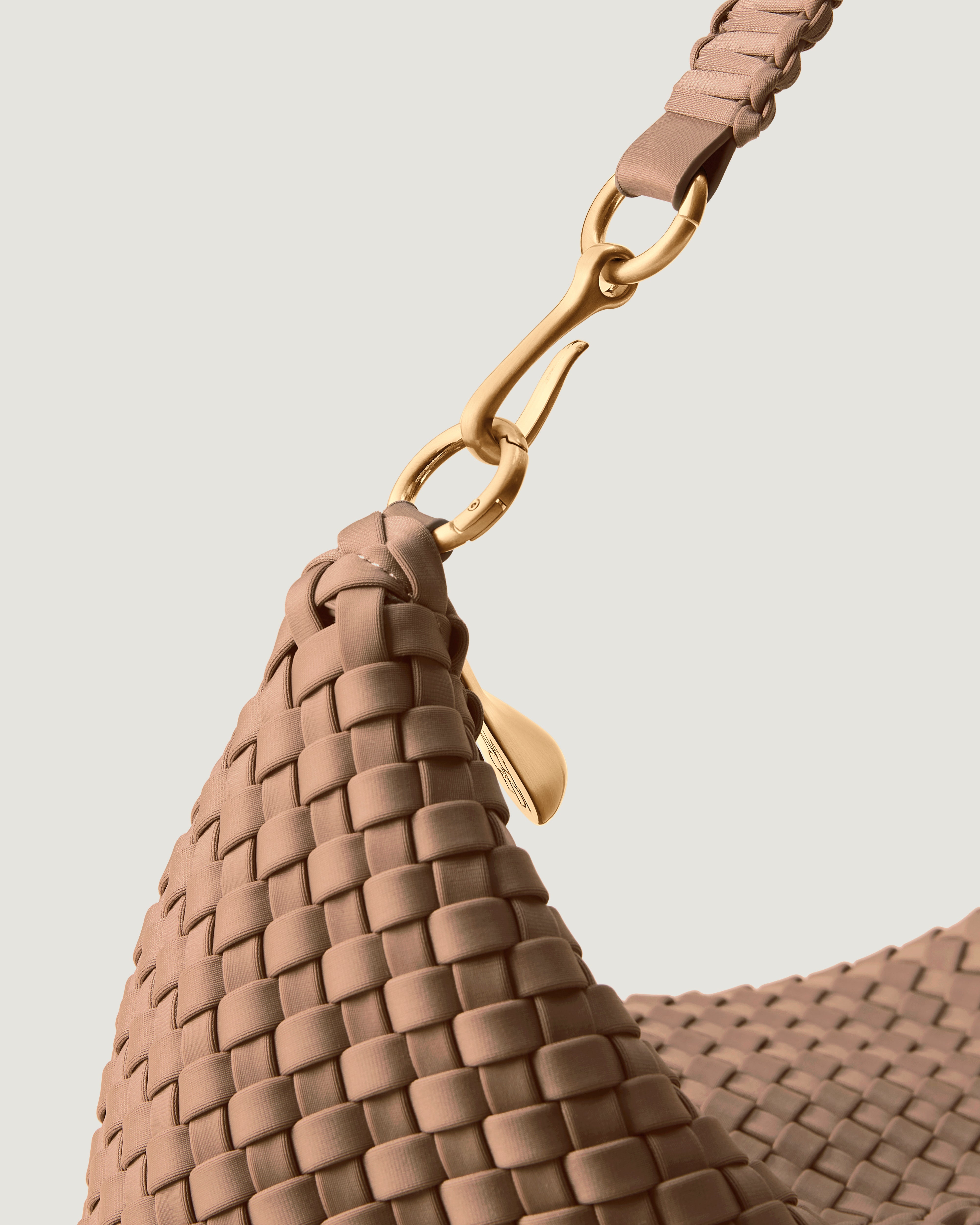 Close-up of zip closure and custom brushed gold strap hardware.